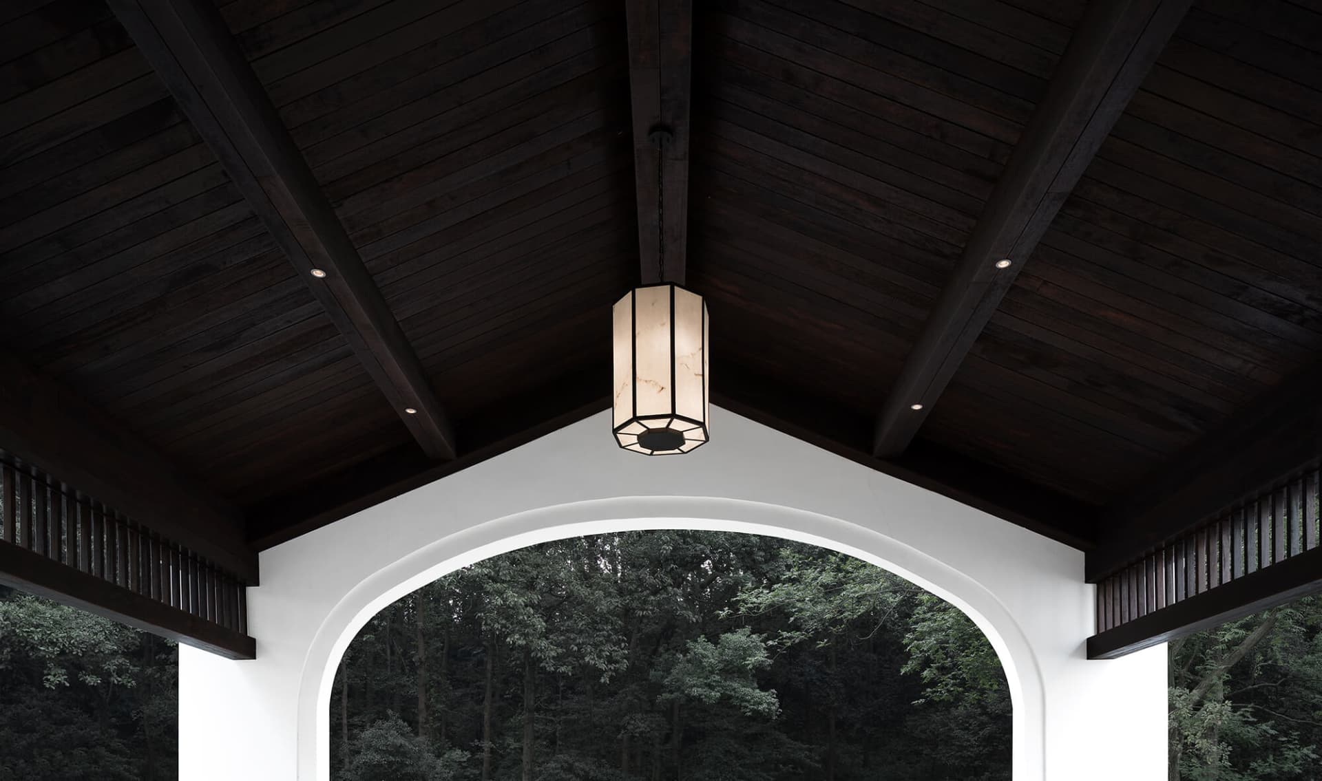 A beautifully designed wooden ceiling with a lantern hanging from it, providing warm lighting.