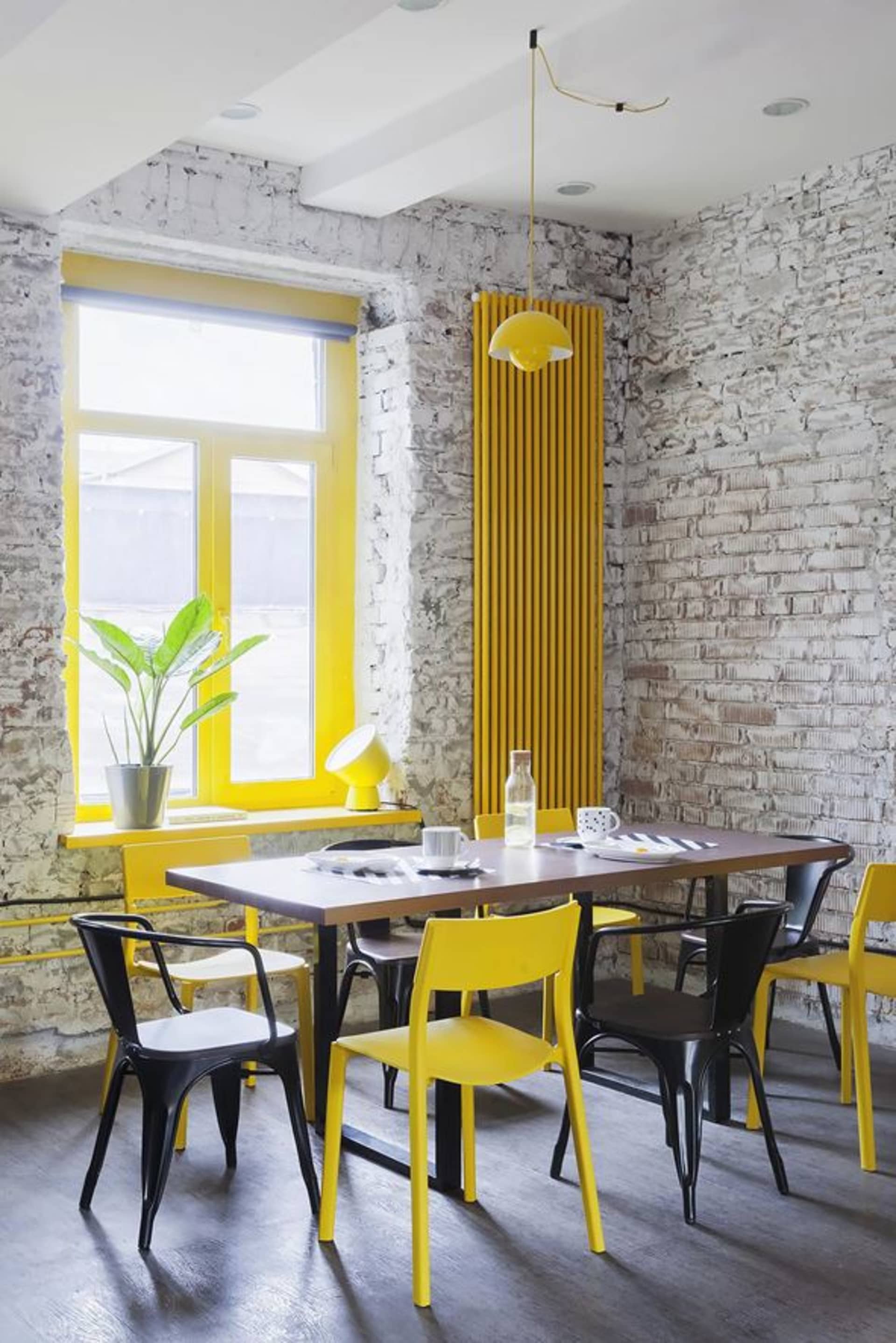 A modern industrial restaurant interior with a yellow brick wall