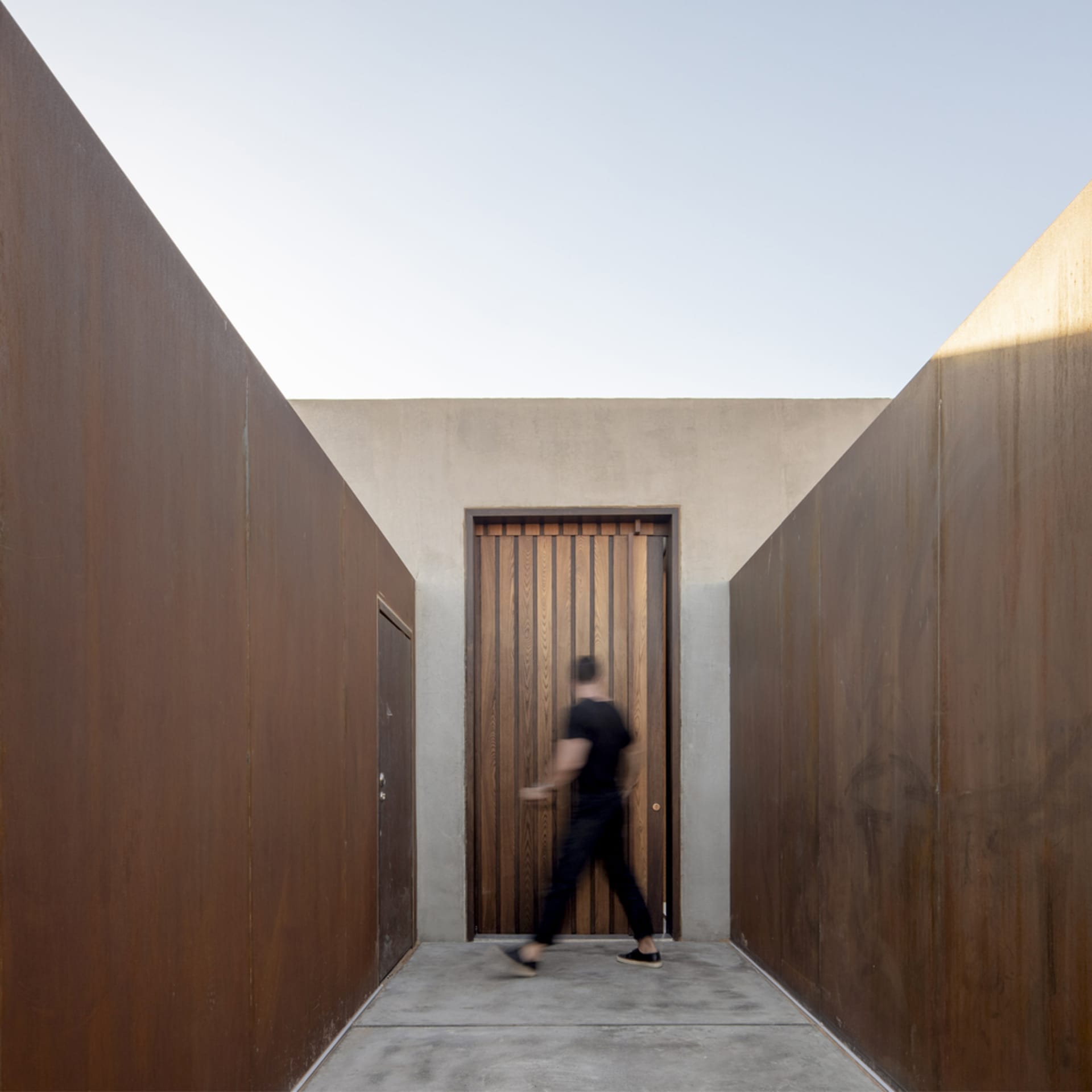 A modern architectural entryway featuring a metal door.