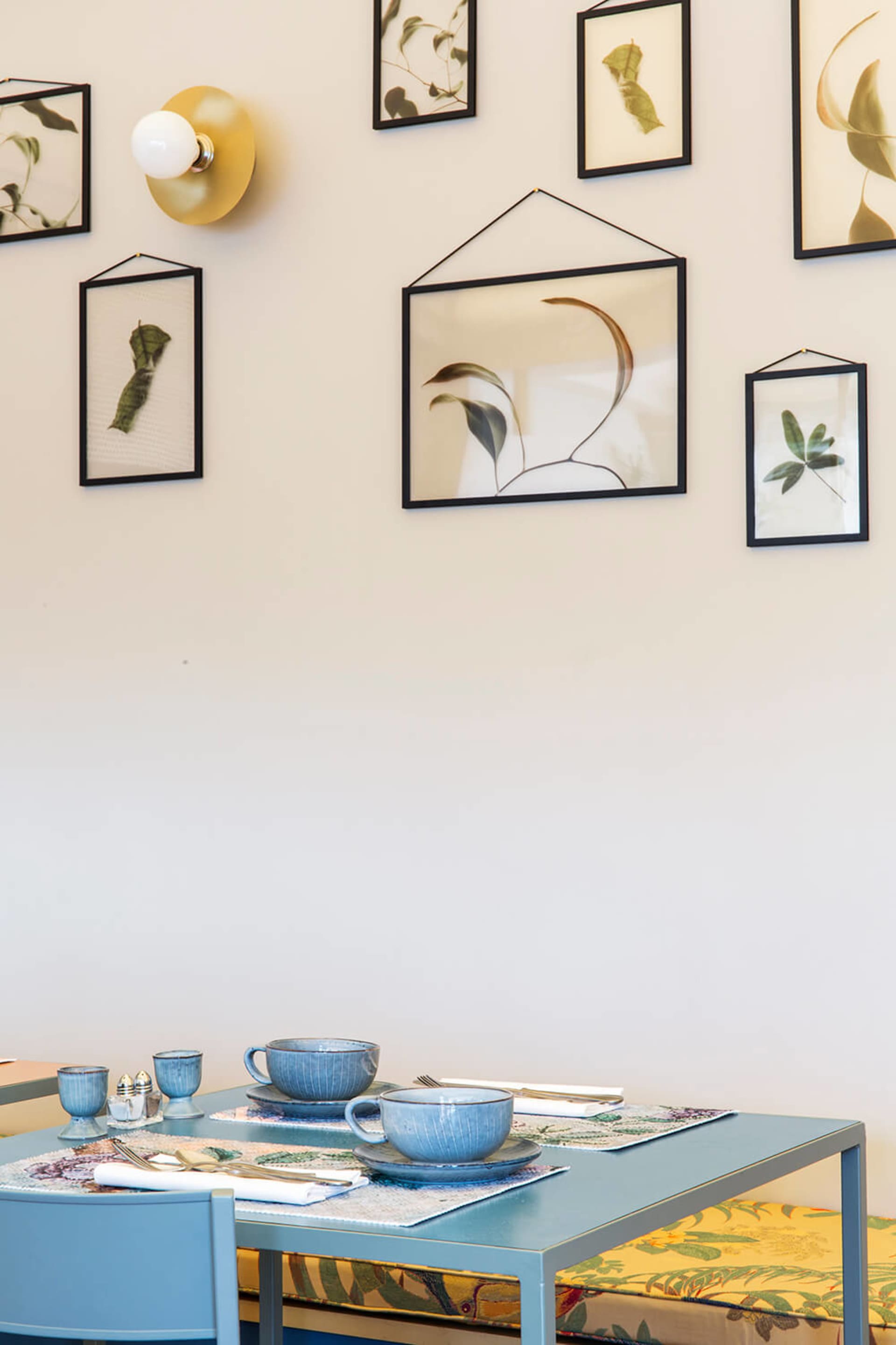 Minimalist dining room featuring ceramic tableware on a blue table.