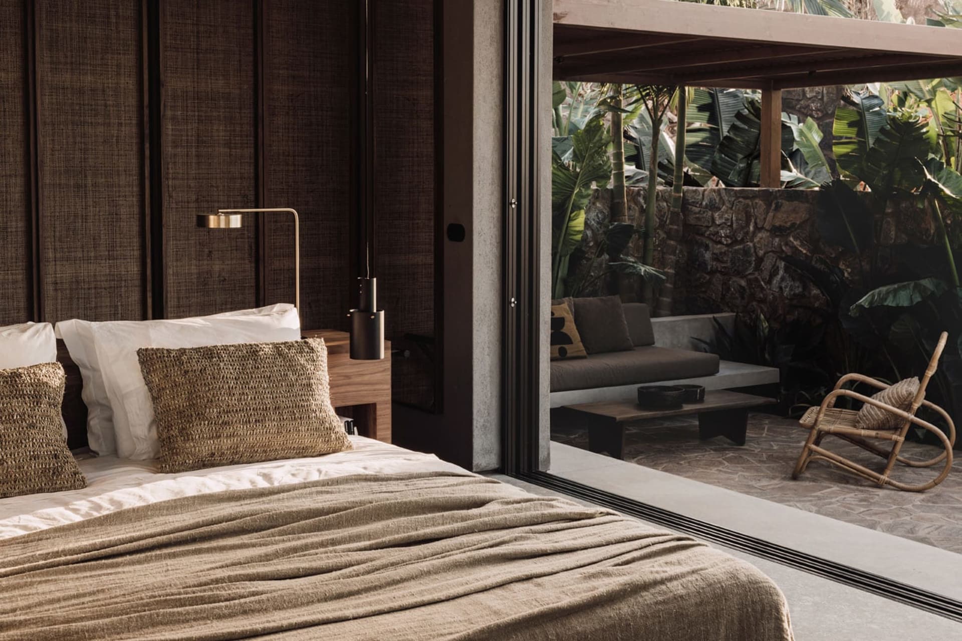 Minimalist bedroom with natural textile accents, showcasing sleek design and cozy elements.