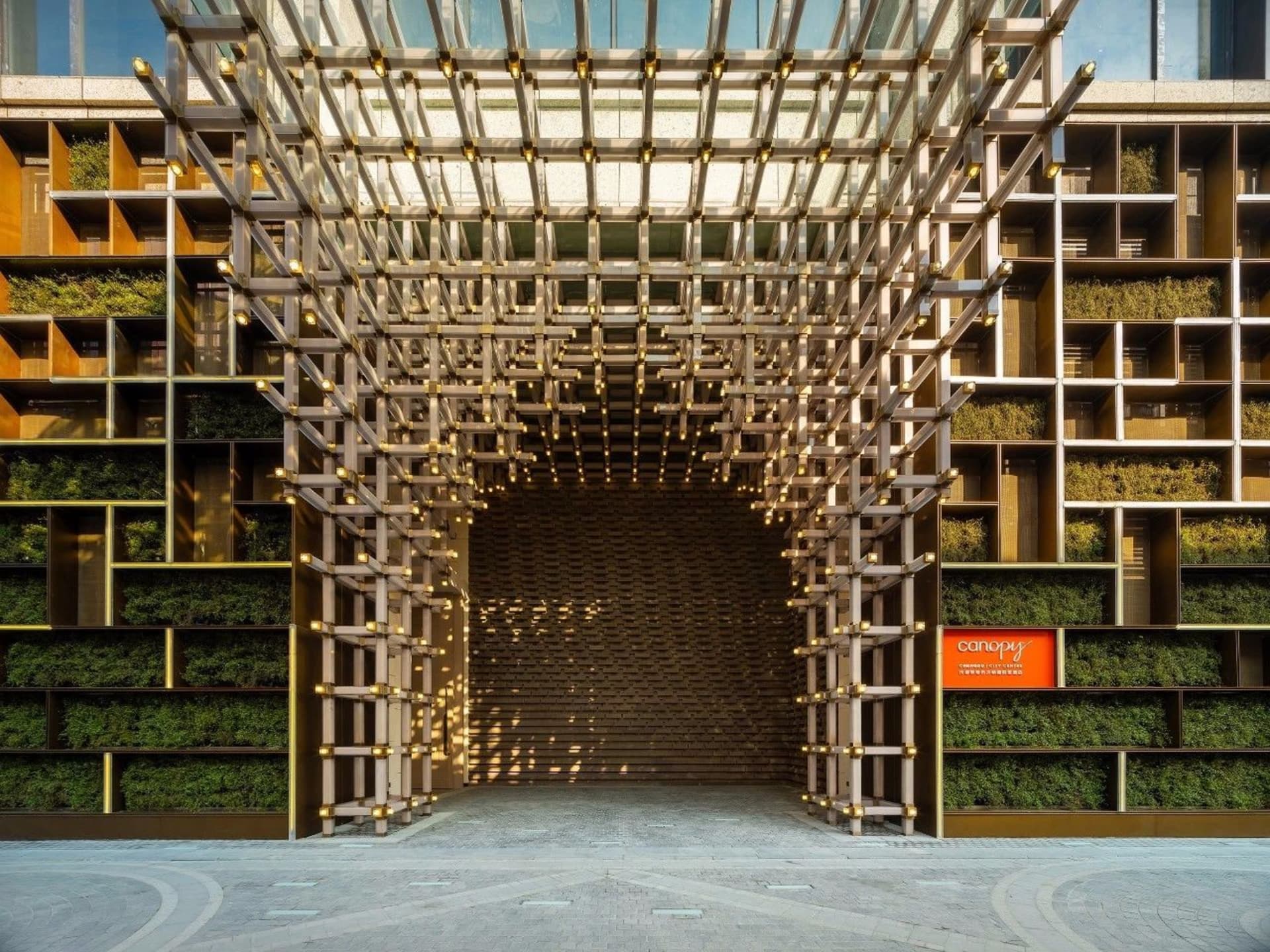 Modern green entrance designed with a steel grid and integrated planters.