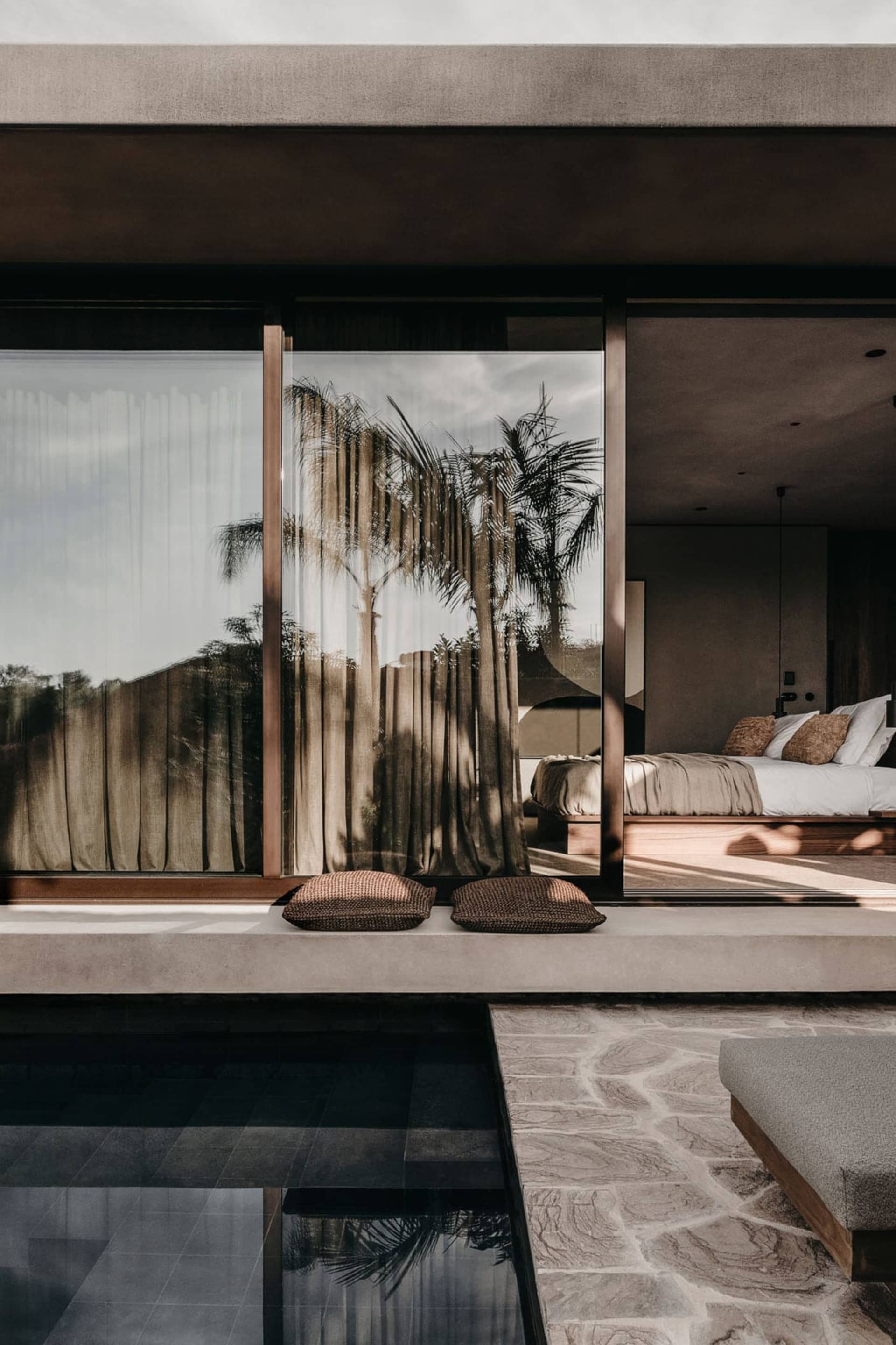 Modern minimalist bedroom featuring concrete and glass materials.
