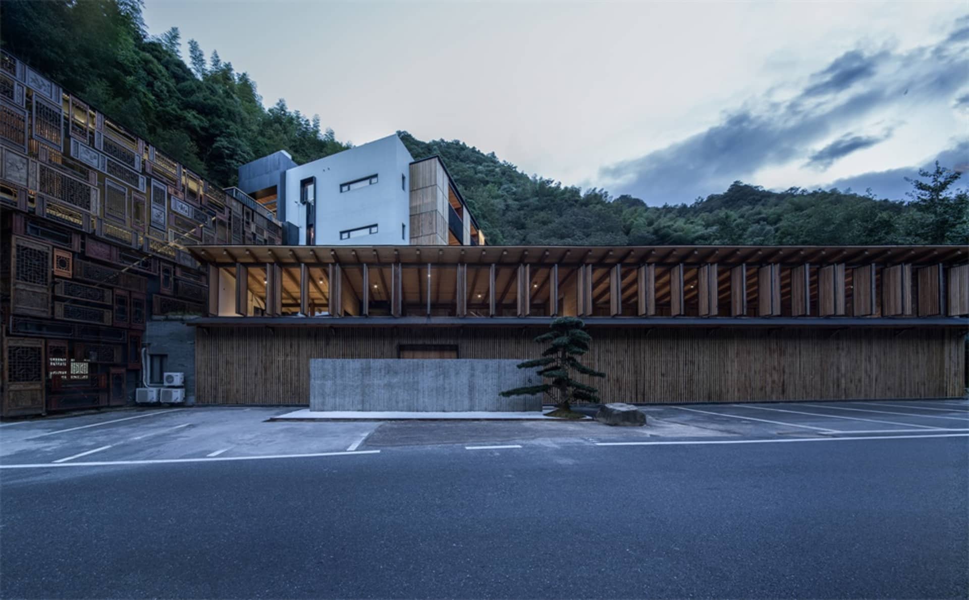 現代住宅建築採用木質與混凝土外觀,背景為自然景觀與山景