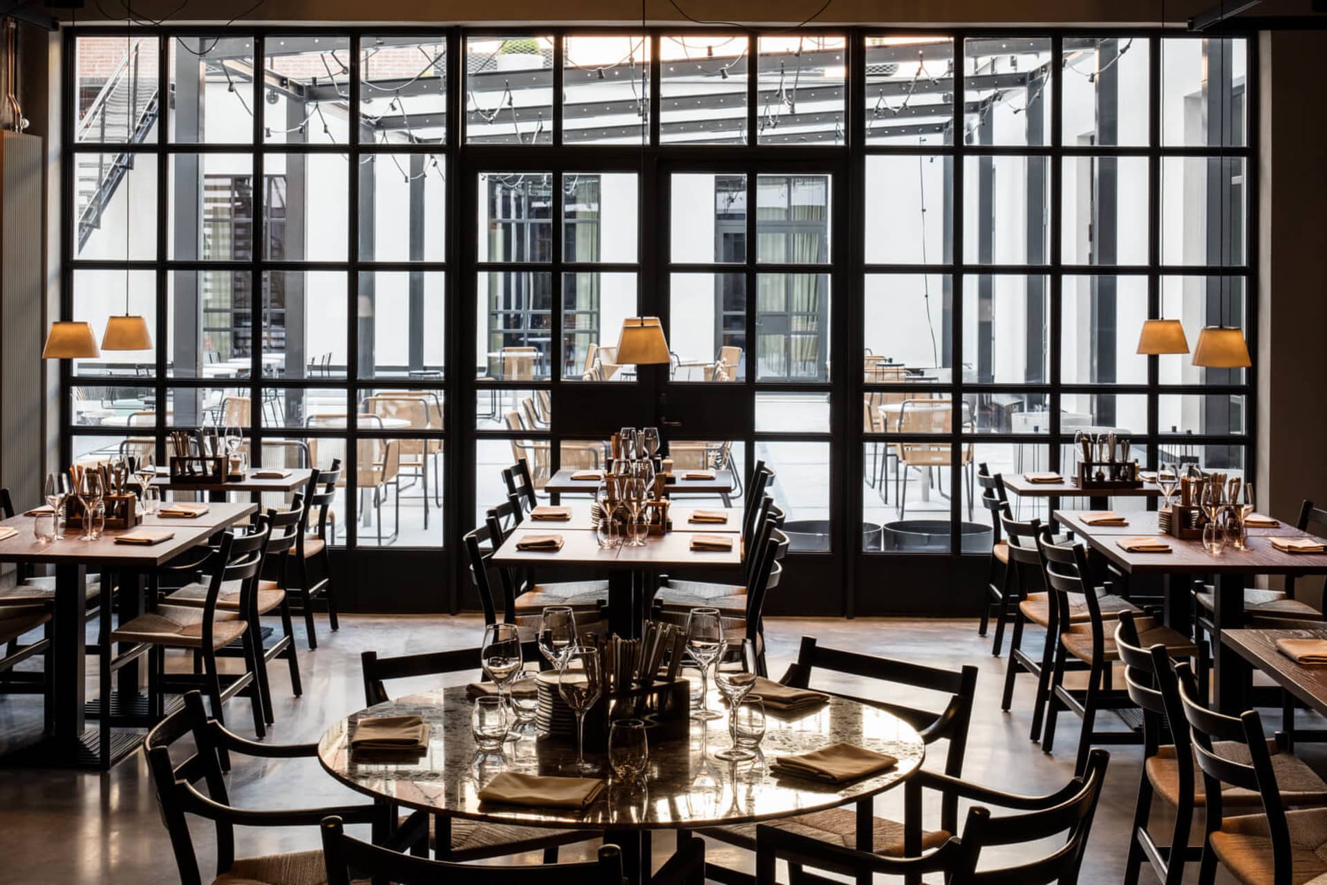 Modern restaurant interior with glass walls and open design layout.