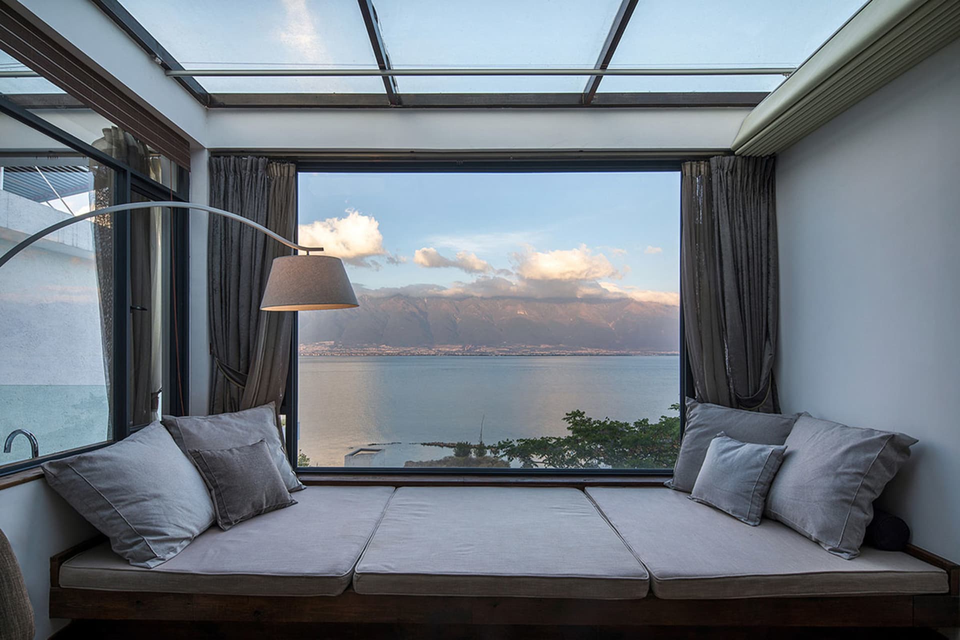 Comfy cushions with sea view, glass windows, and curtains