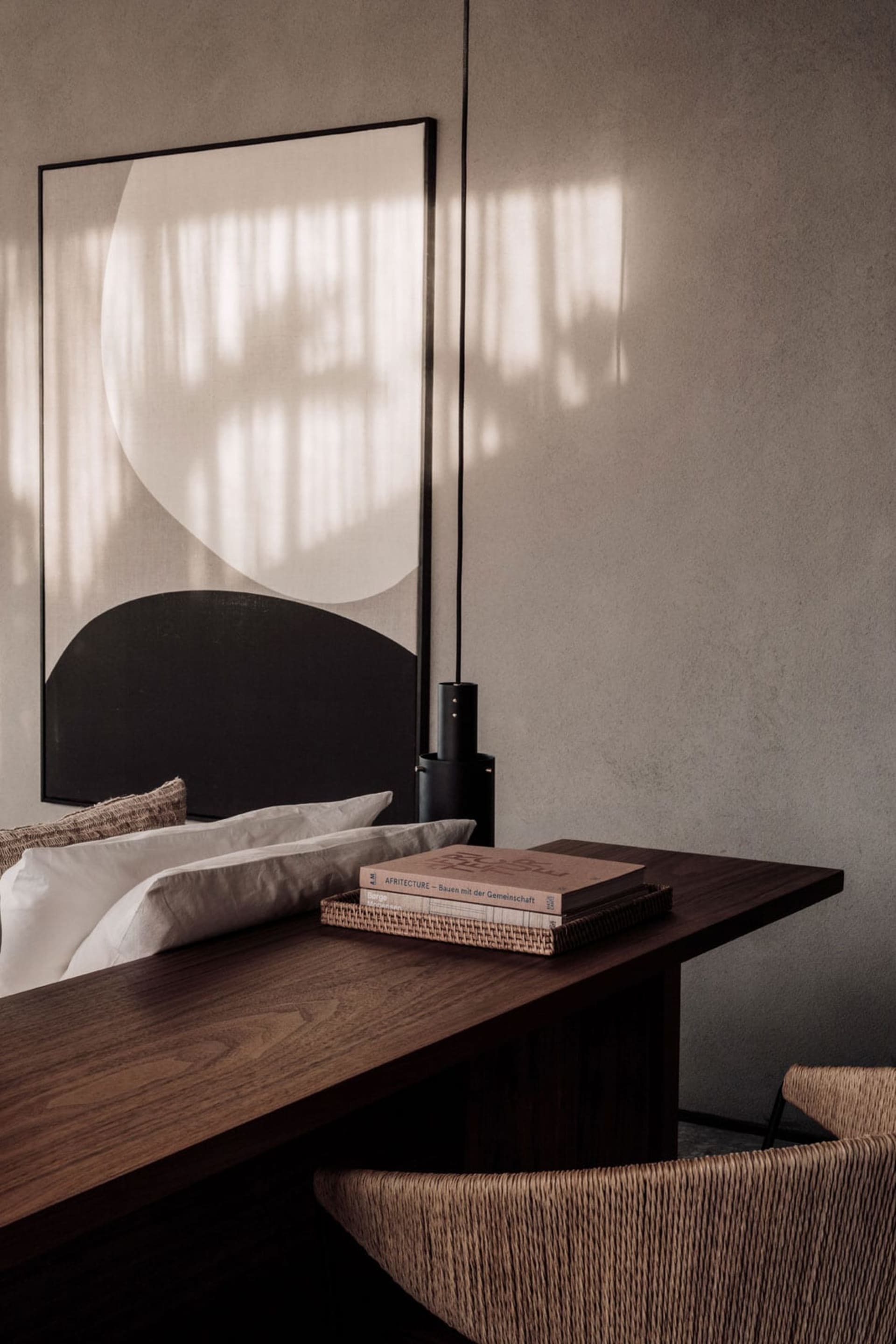 Modern minimalist living space with a textured paper-covered worktable and a large abstract artwork featuring geometric shape