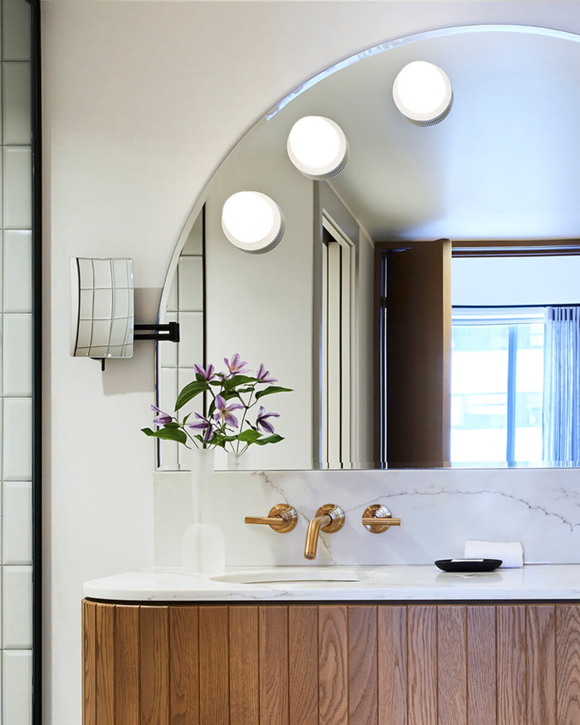 Modern bathroom design featuring a marble countertop and wood cabinetry.