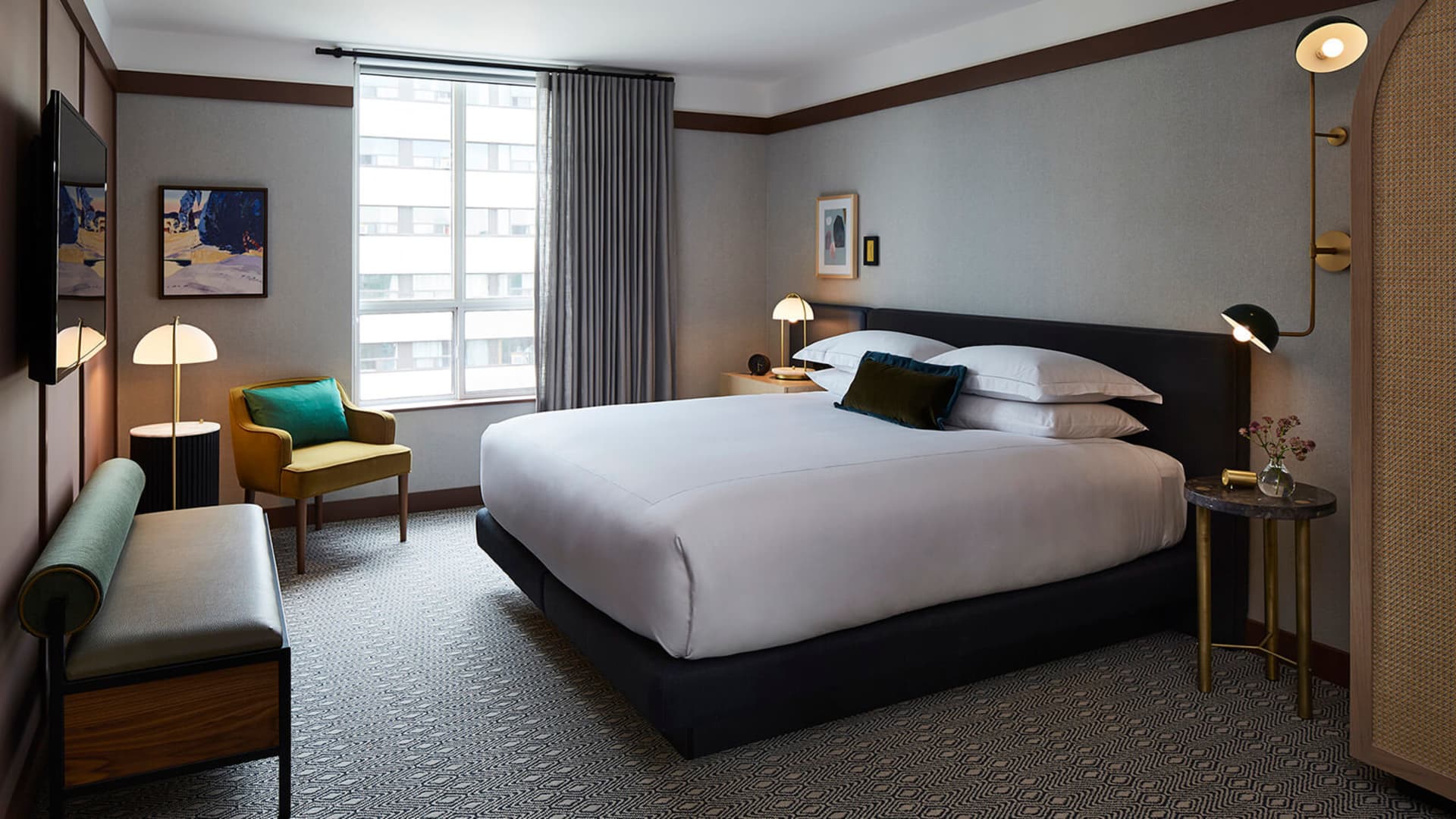 A well-designed, minimalist hotel room featuring modern furniture and textured fabrics.