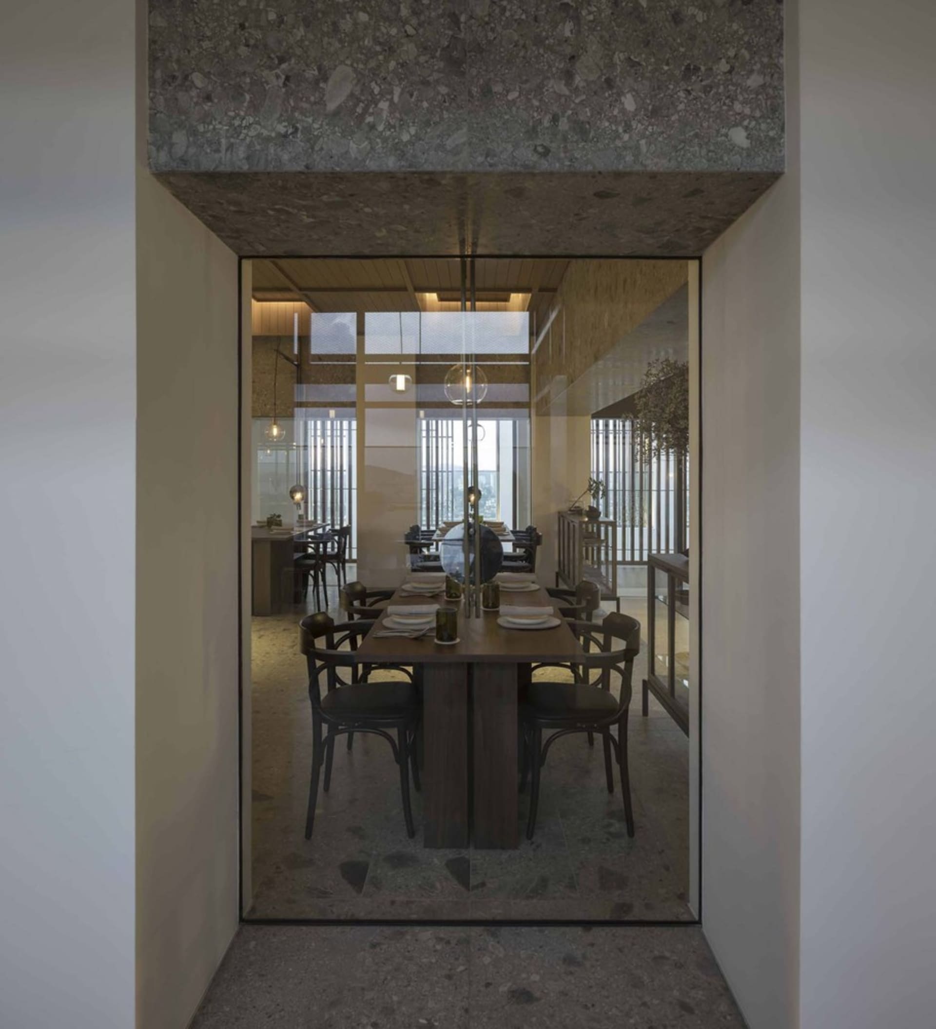 Modern dining room featuring wooden tables and glass walls.