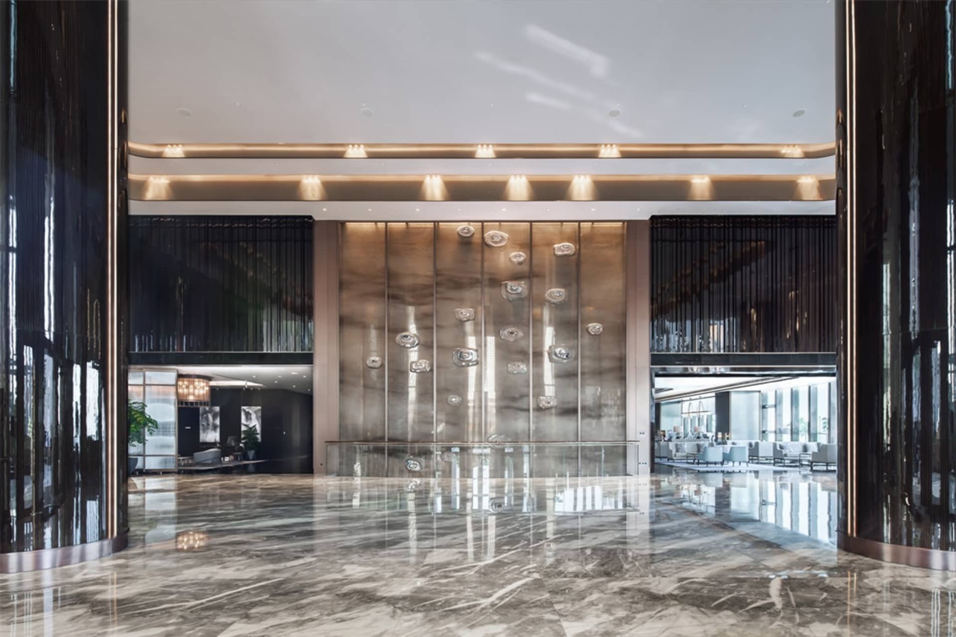 A modern hotel lobby featuring a spacious and elegant marble floor.