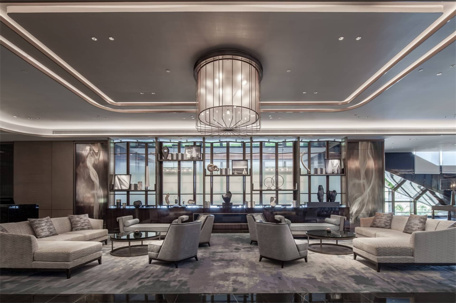 A modern hotel lobby featuring marble, glass, and metal decor.