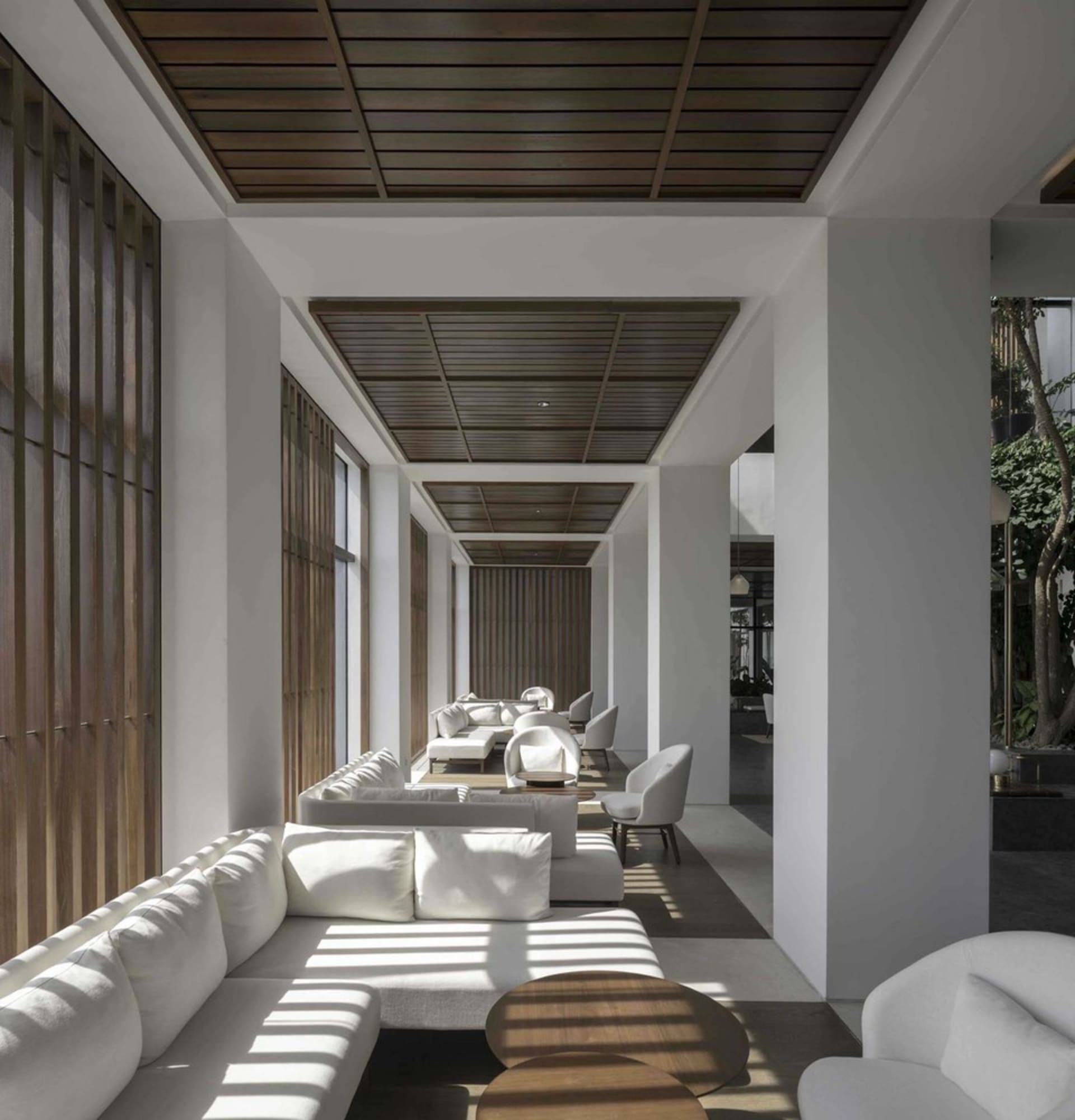 A modern living room with white wooden paneled walls and furniture.