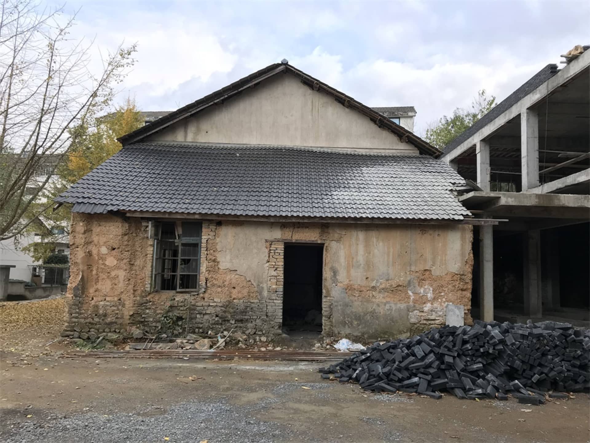 一座老舊廢棄建築，外牆有裂縫，屋頂覆蓋瓦片。