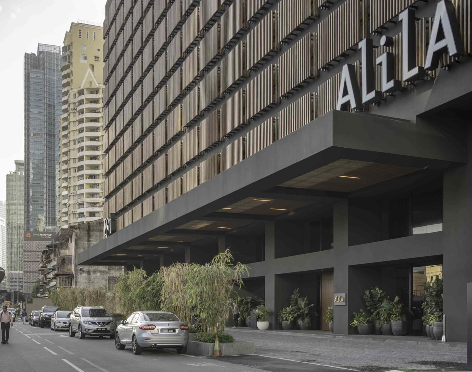 A modern hotel building with a bold, metallic exterior featuring a large sign.