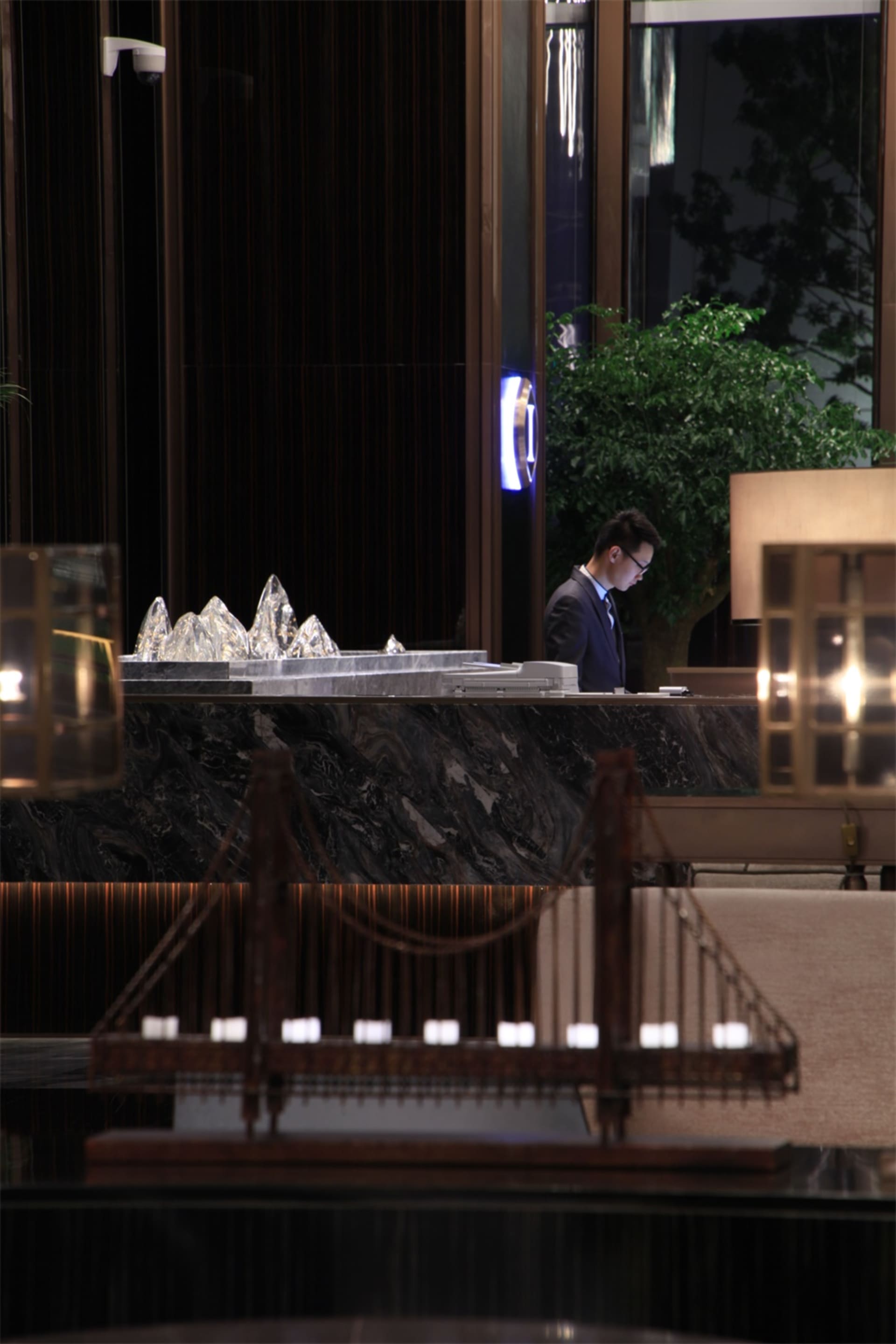 現代酒店接待櫃檯,搭配大理石檯面與玻璃雕塑。