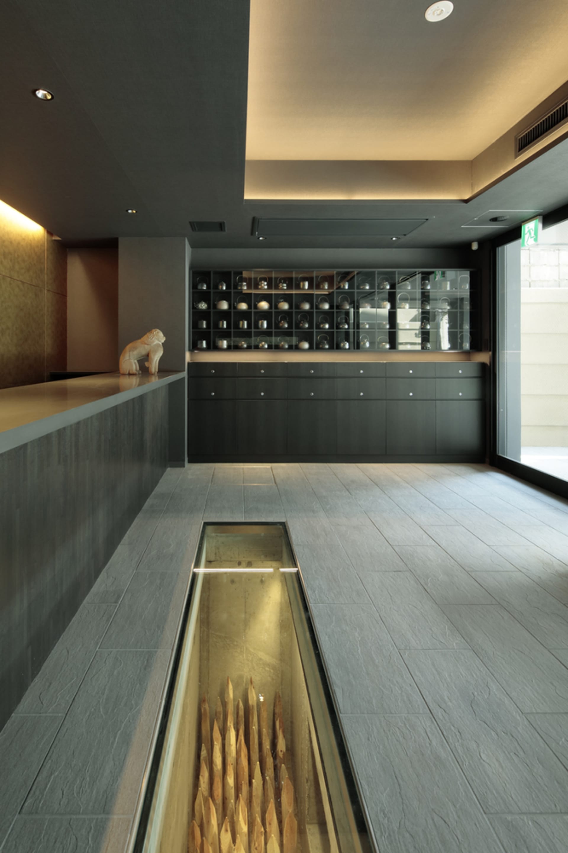 A modern interior design of a concrete lobby with a glass case.