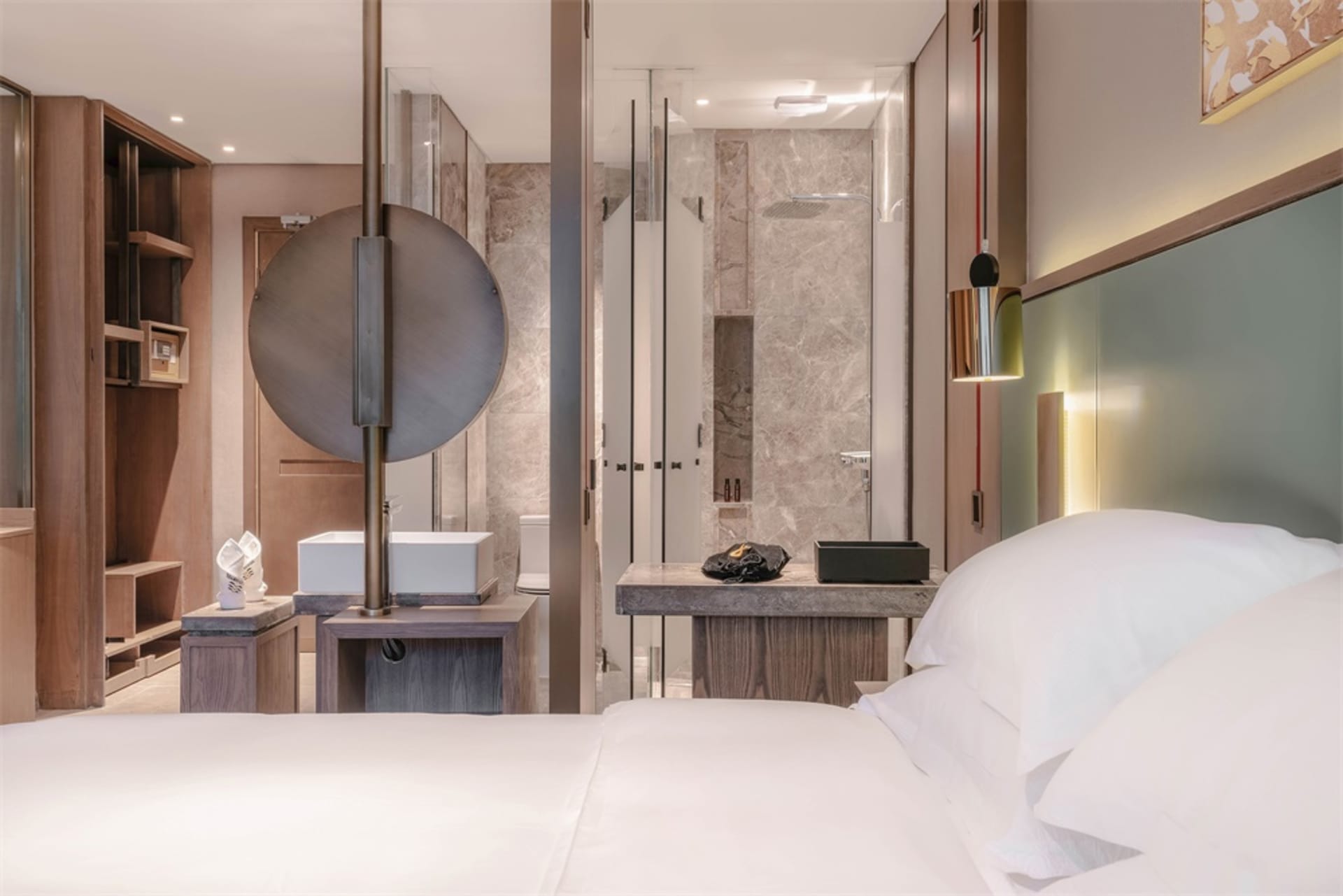 Modern bedroom with minimalist design, white bedding, and integrated bathroom.