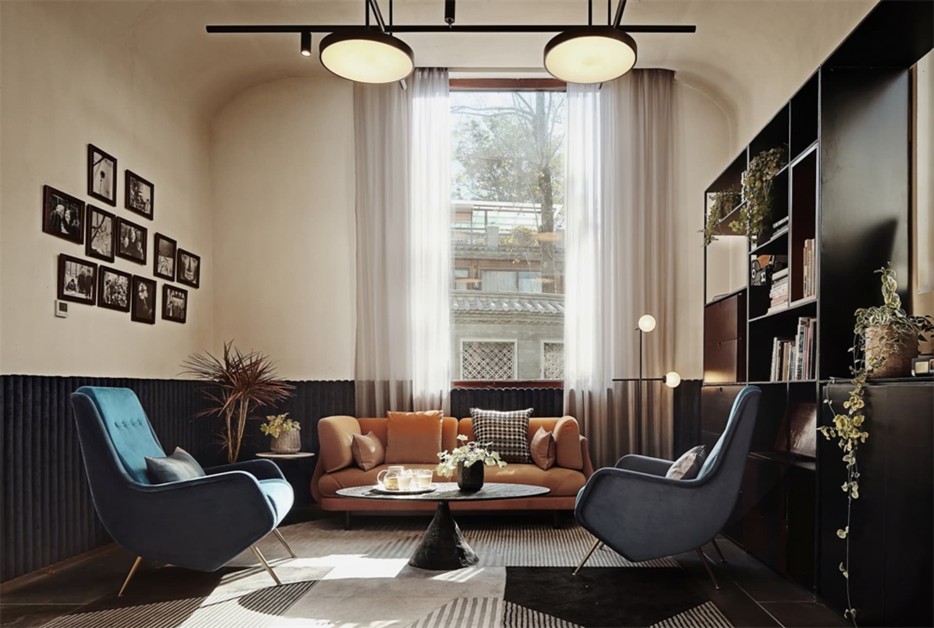 Minimalist living room featuring a brown couch, blue armchairs, and textured decor.