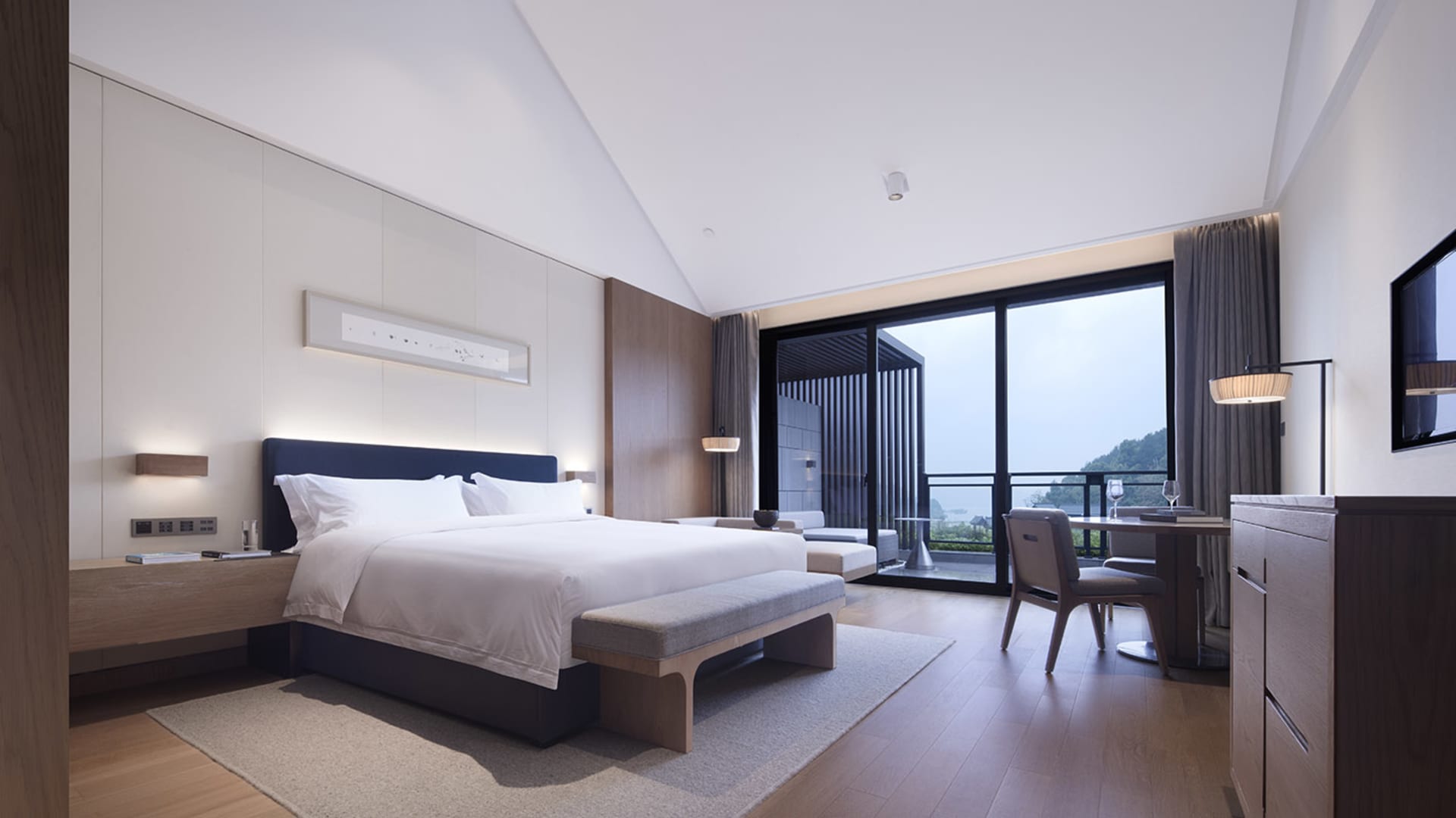 Modern bedroom with wooden accents and a large window overlooking nature.