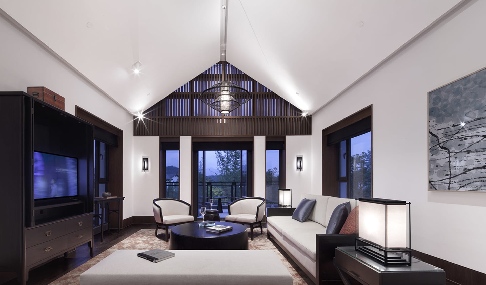 Modern living room with white furniture, wooden accents, and large windows.