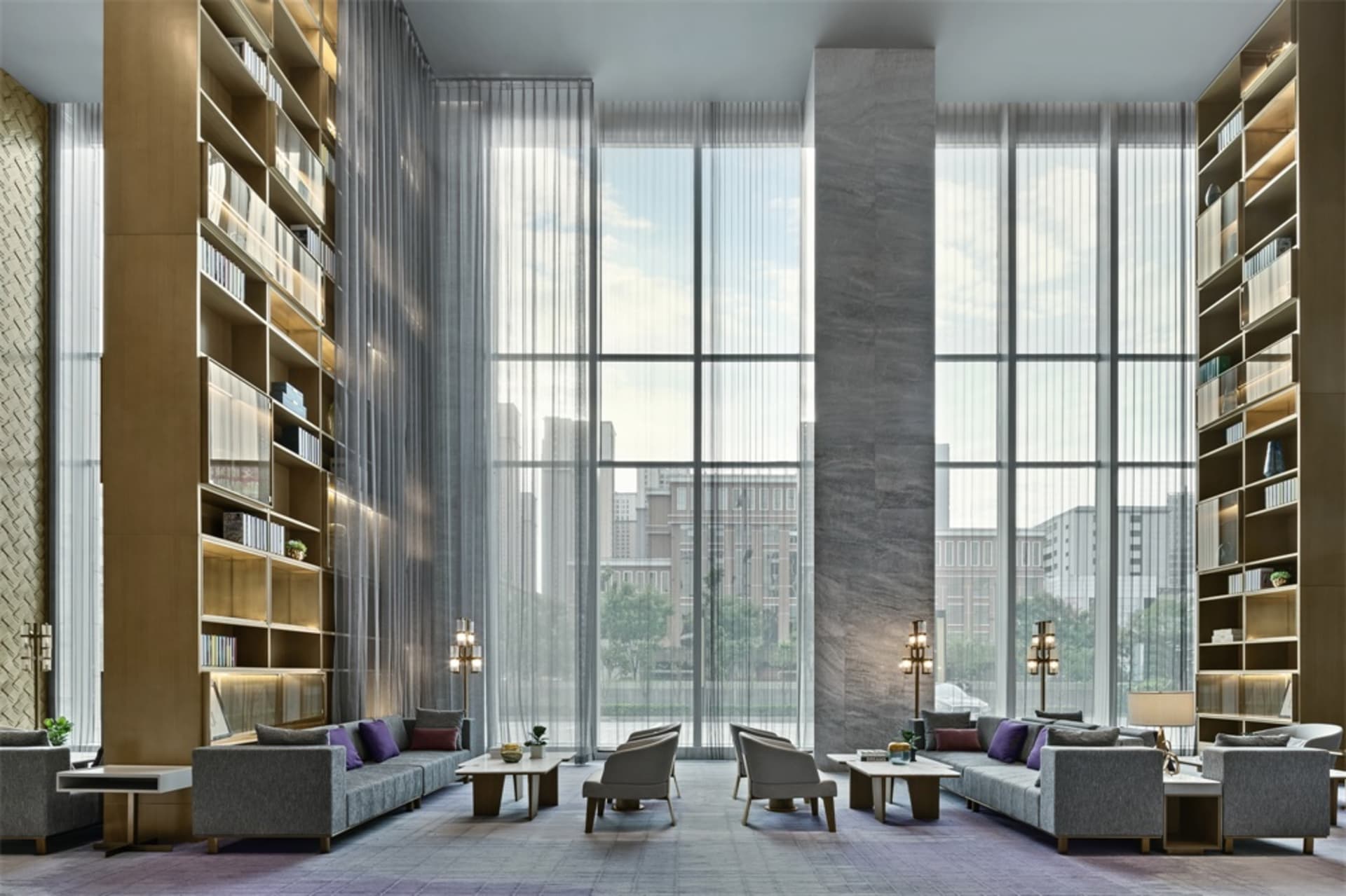 Modern hotel lobby featuring large glass windows overlooking a cityscape