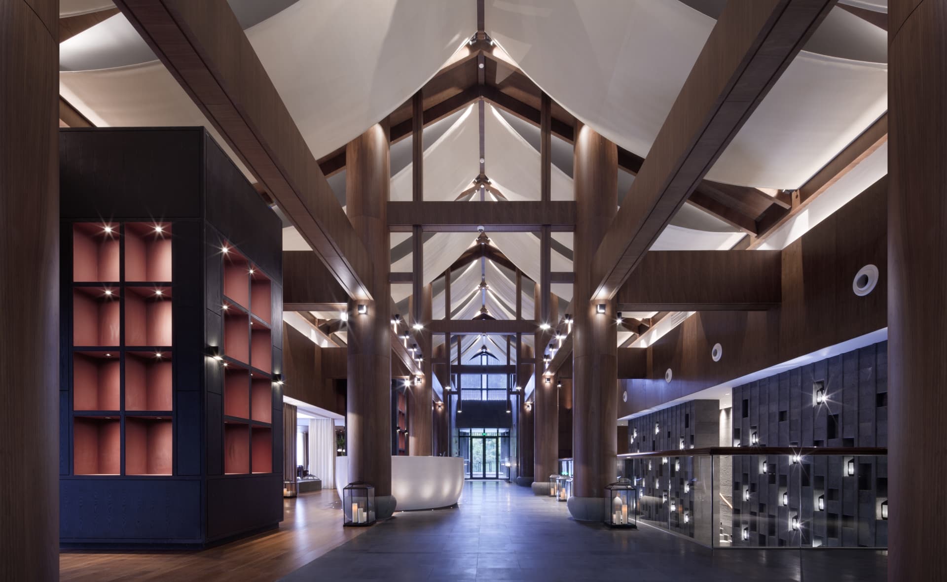 Modern lobby interior with wooden columns and high ceilings.