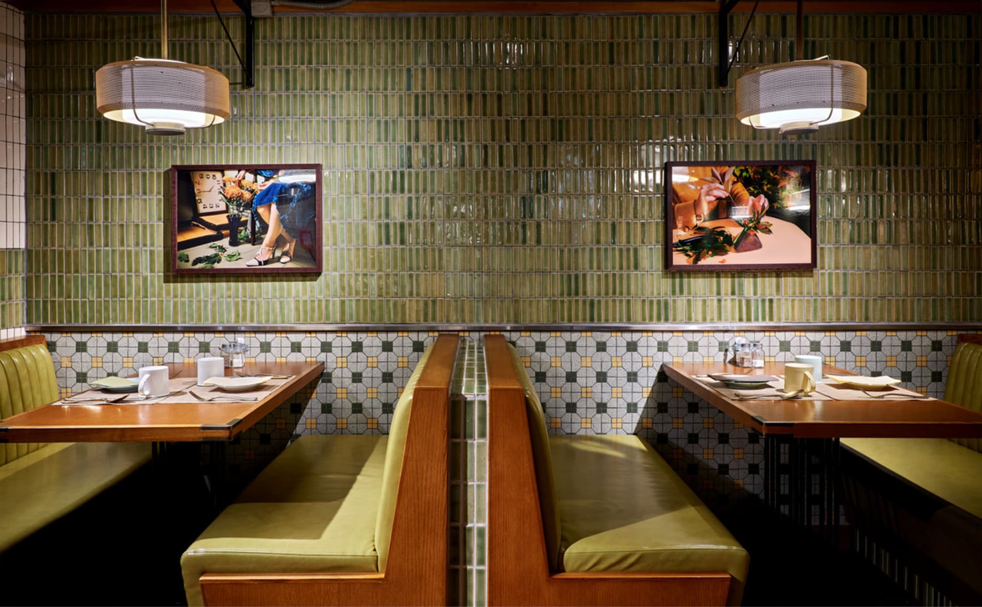 Restaurant interior with green tile walls and wooden tables with white tablecloths