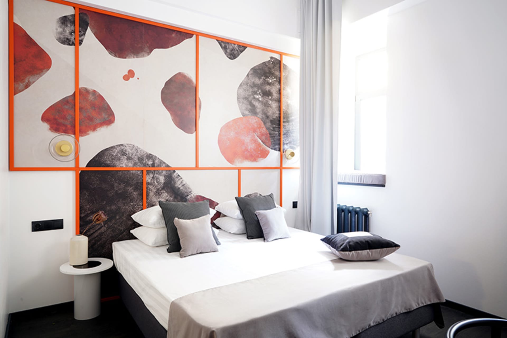 Minimalist bedroom with a sound-absorbing fabric and a decorated wall