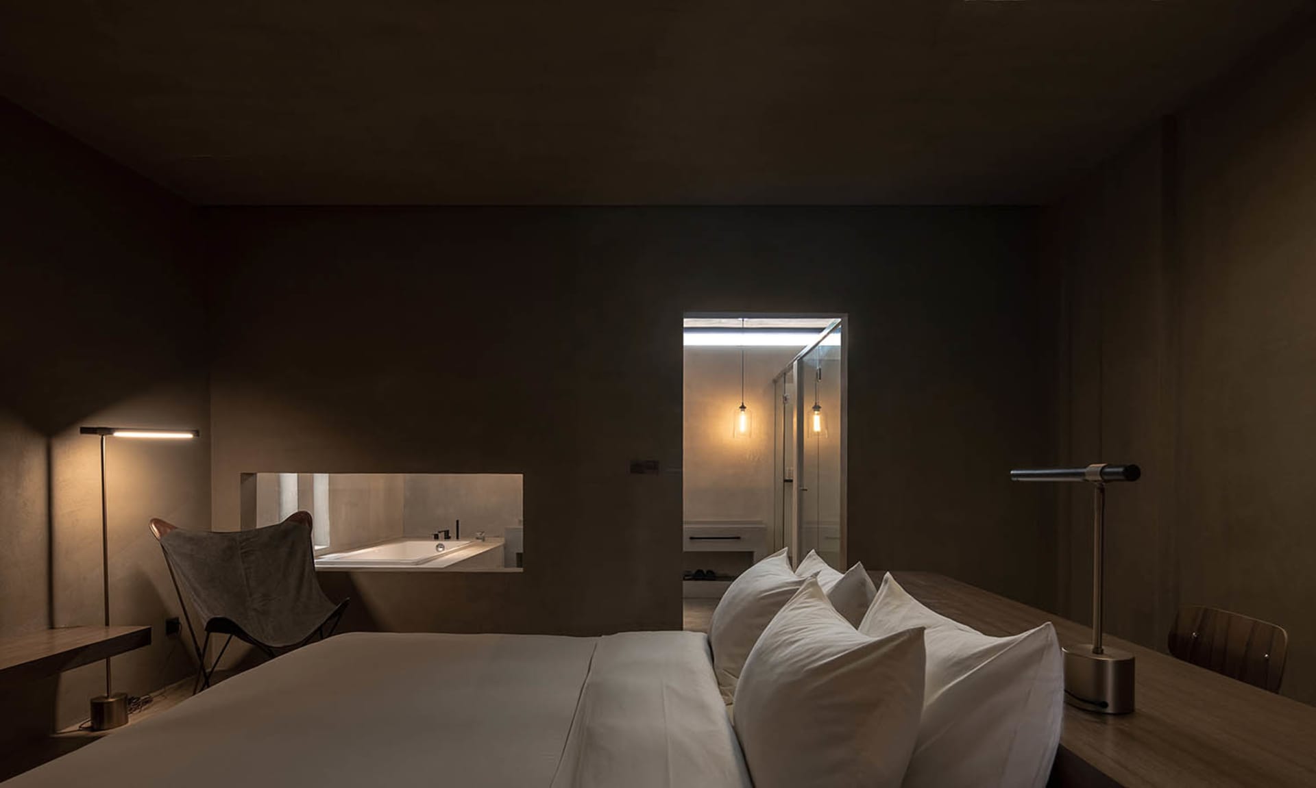 Well-designed, modern hotel room interior with a concrete floor and minimalist furniture.