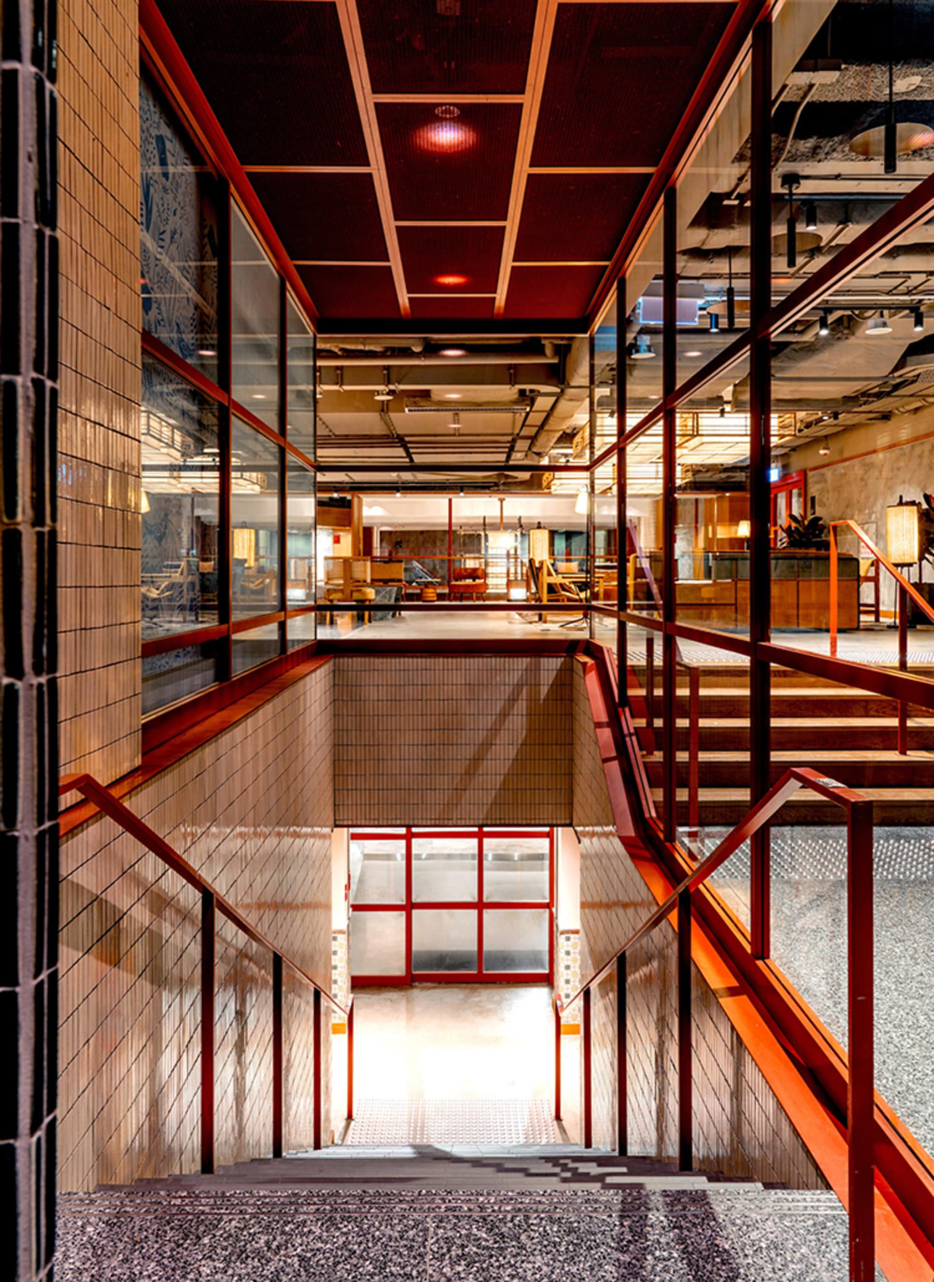 Modern industrial commercial lobby with concrete, glass, and metal materials.
