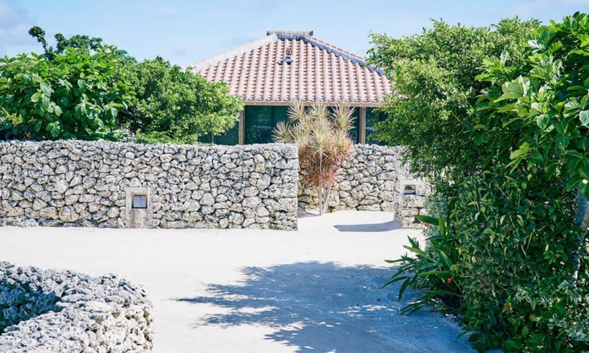 An exterior view of a house featuring a stone wall.