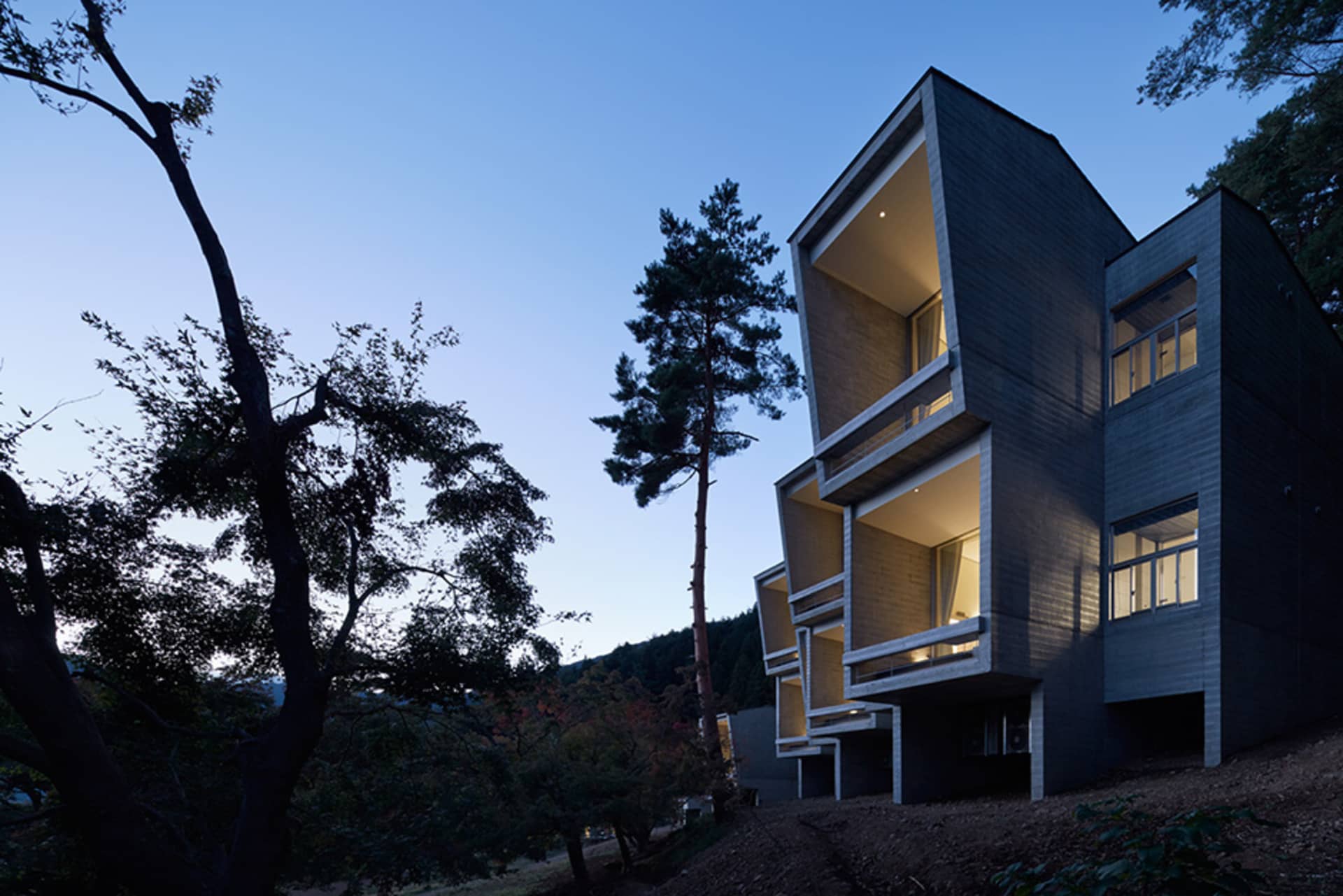 A modern residential building with concrete and glass exterior materials.