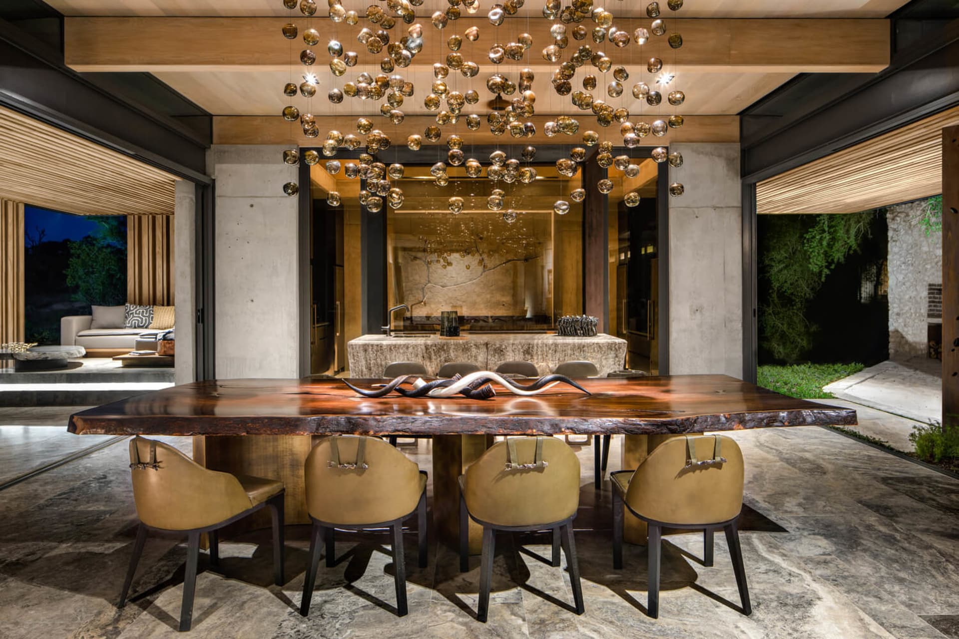 A modern industrial dining room with a large wooden table and concrete pillars