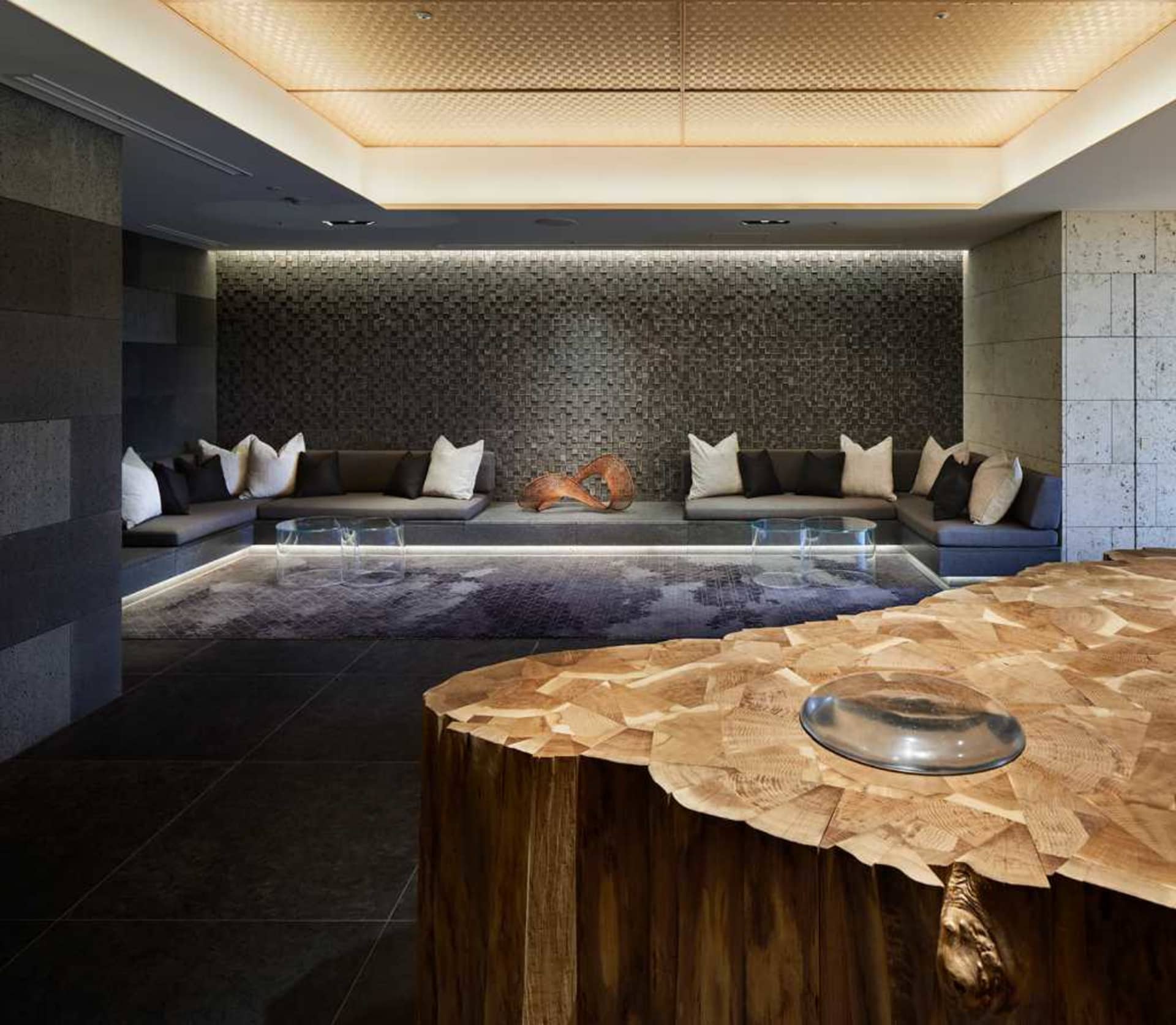 Modern hotel lobby with concrete walls, industrial design elements, and natural light.