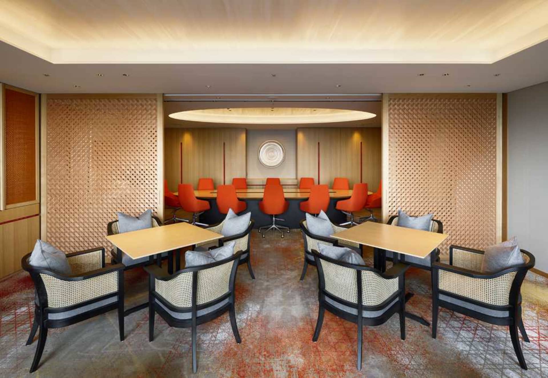 A well-decorated conference room with wooden tables and orange chairs.