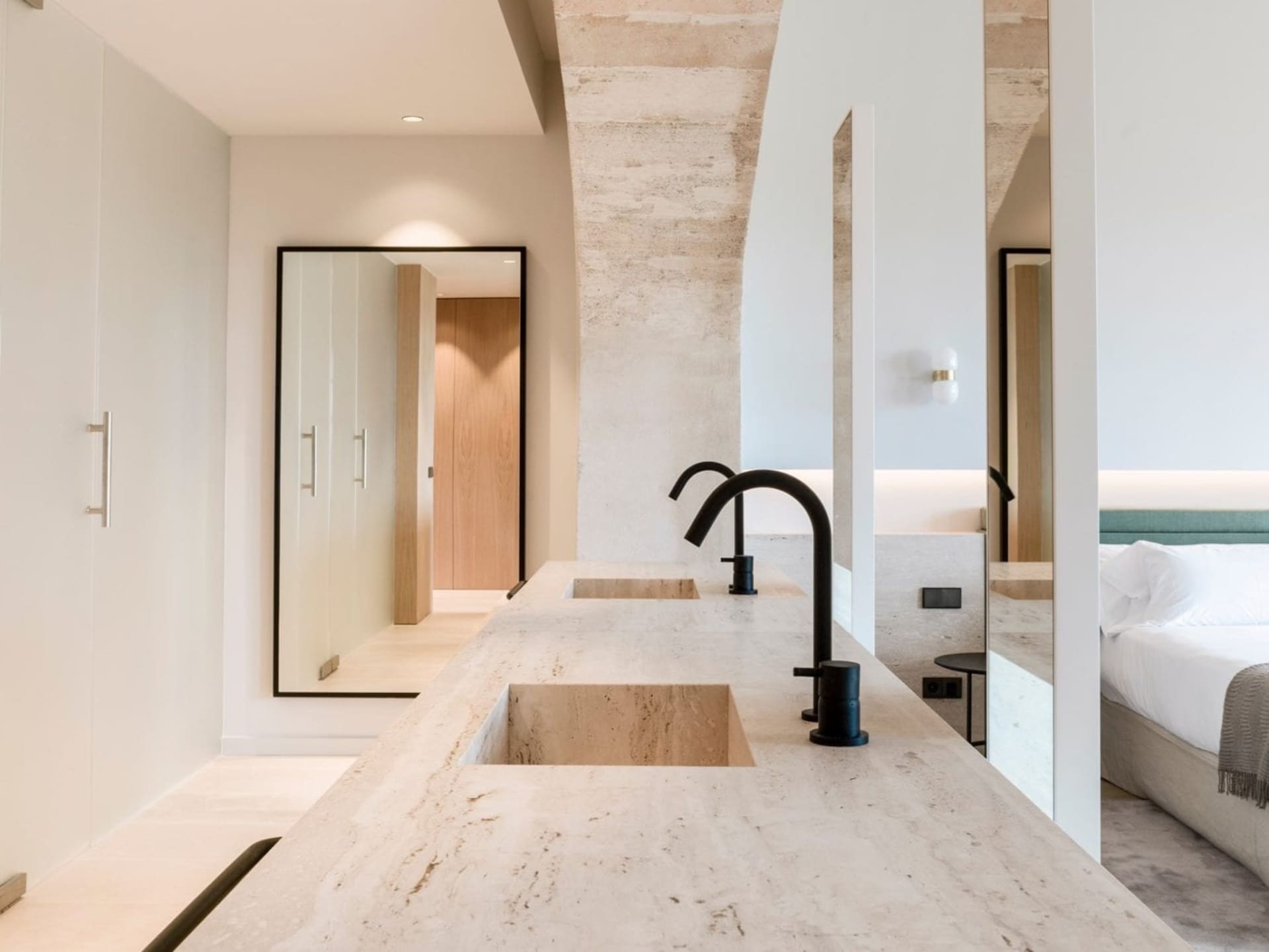 Modern bathroom featuring a minimalist design with marble countertops and black fixtures.