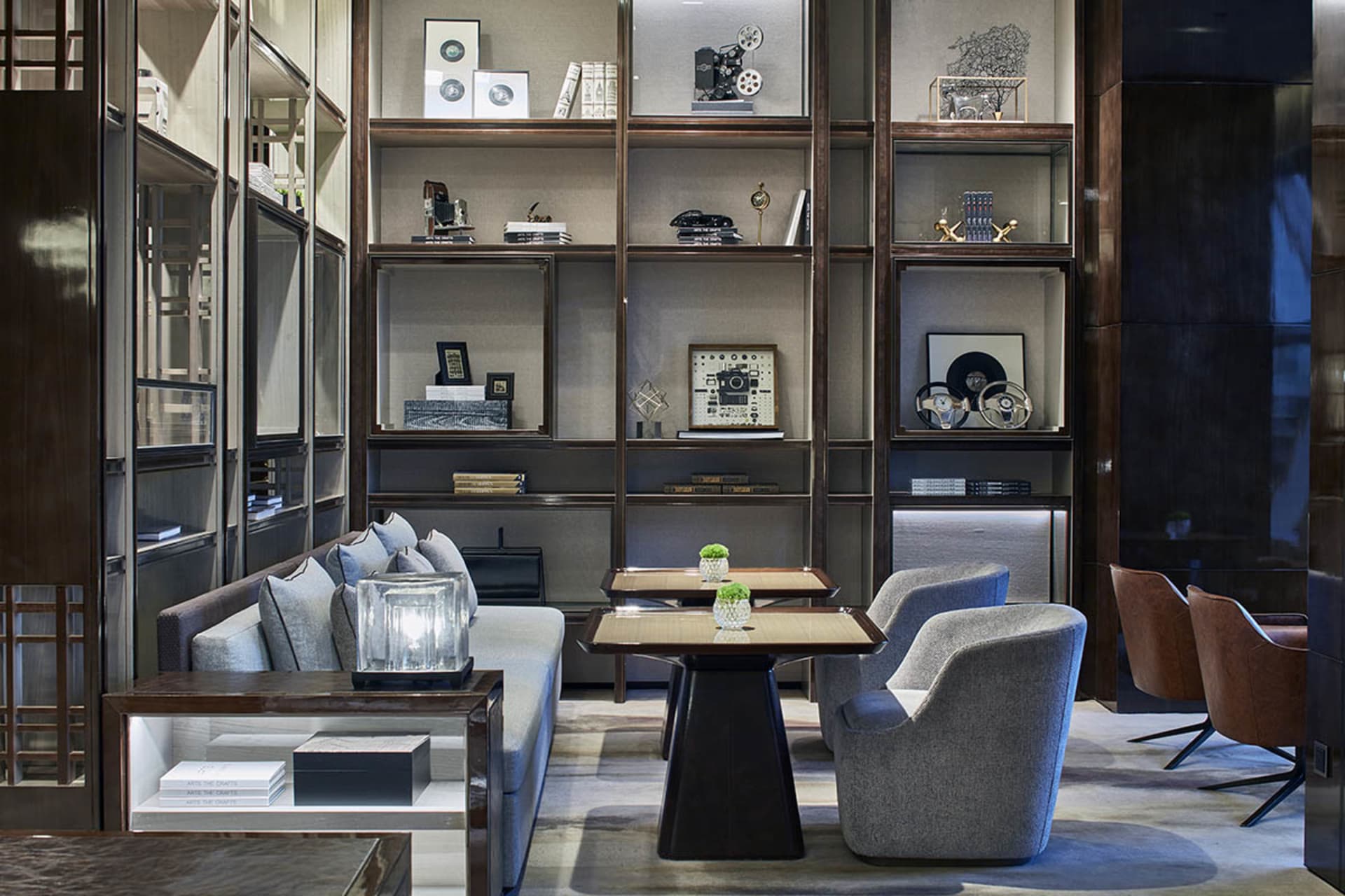 Modern lounge area with contemporary furniture and shelving units displaying decorative items.