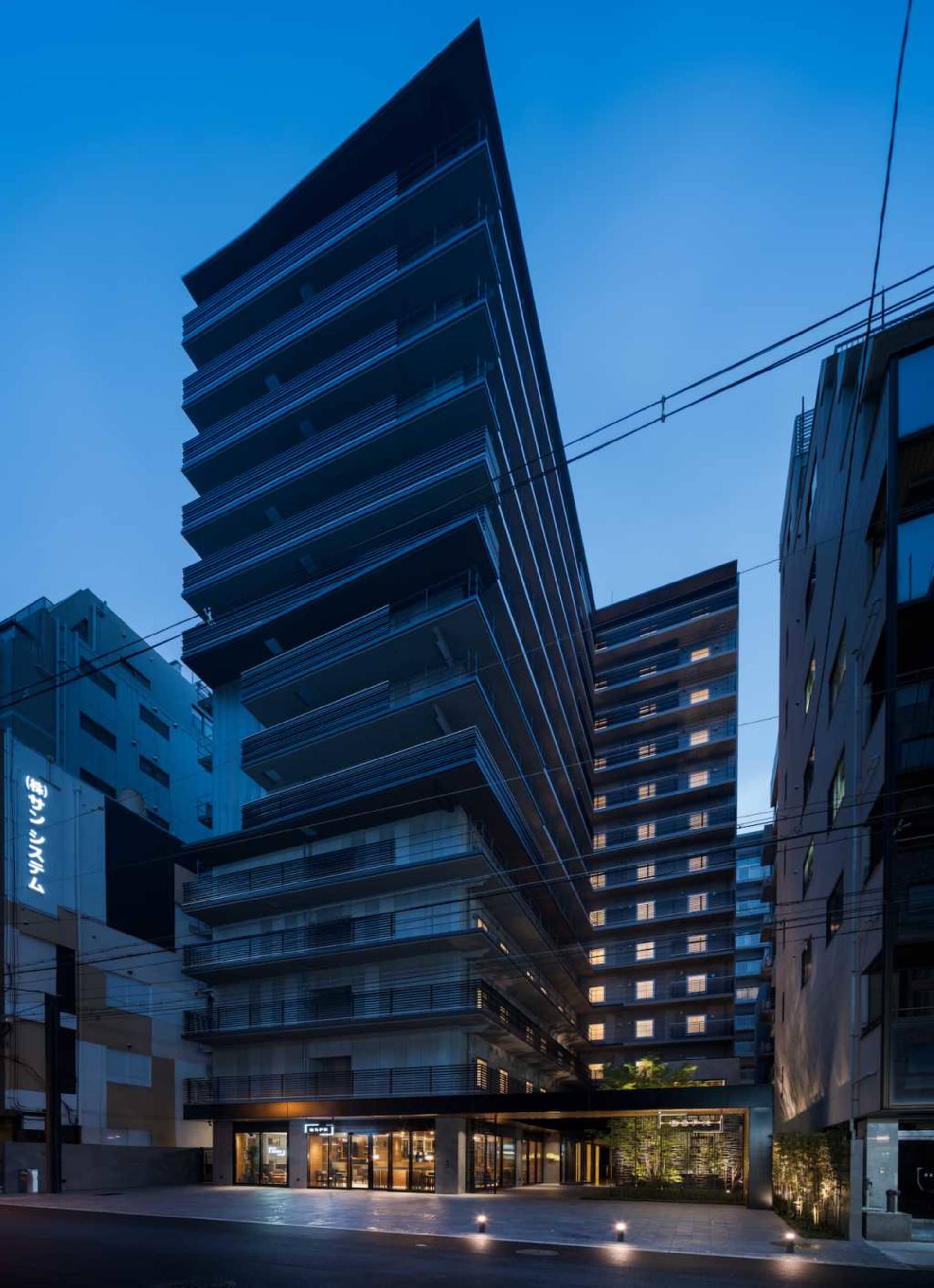 A modern, modular hotel front with dark metal-clad boards.