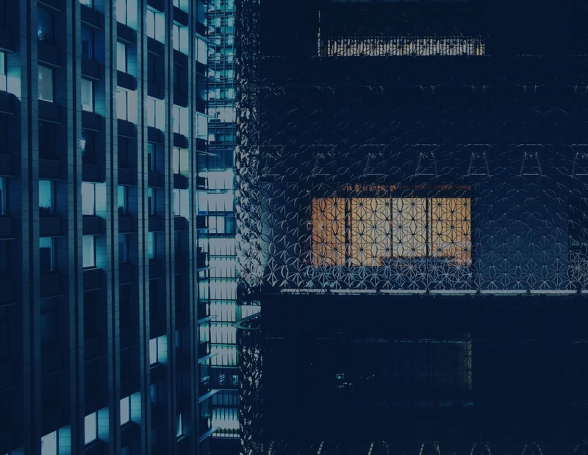 A modern office building with glass windows reflecting a cityscape.