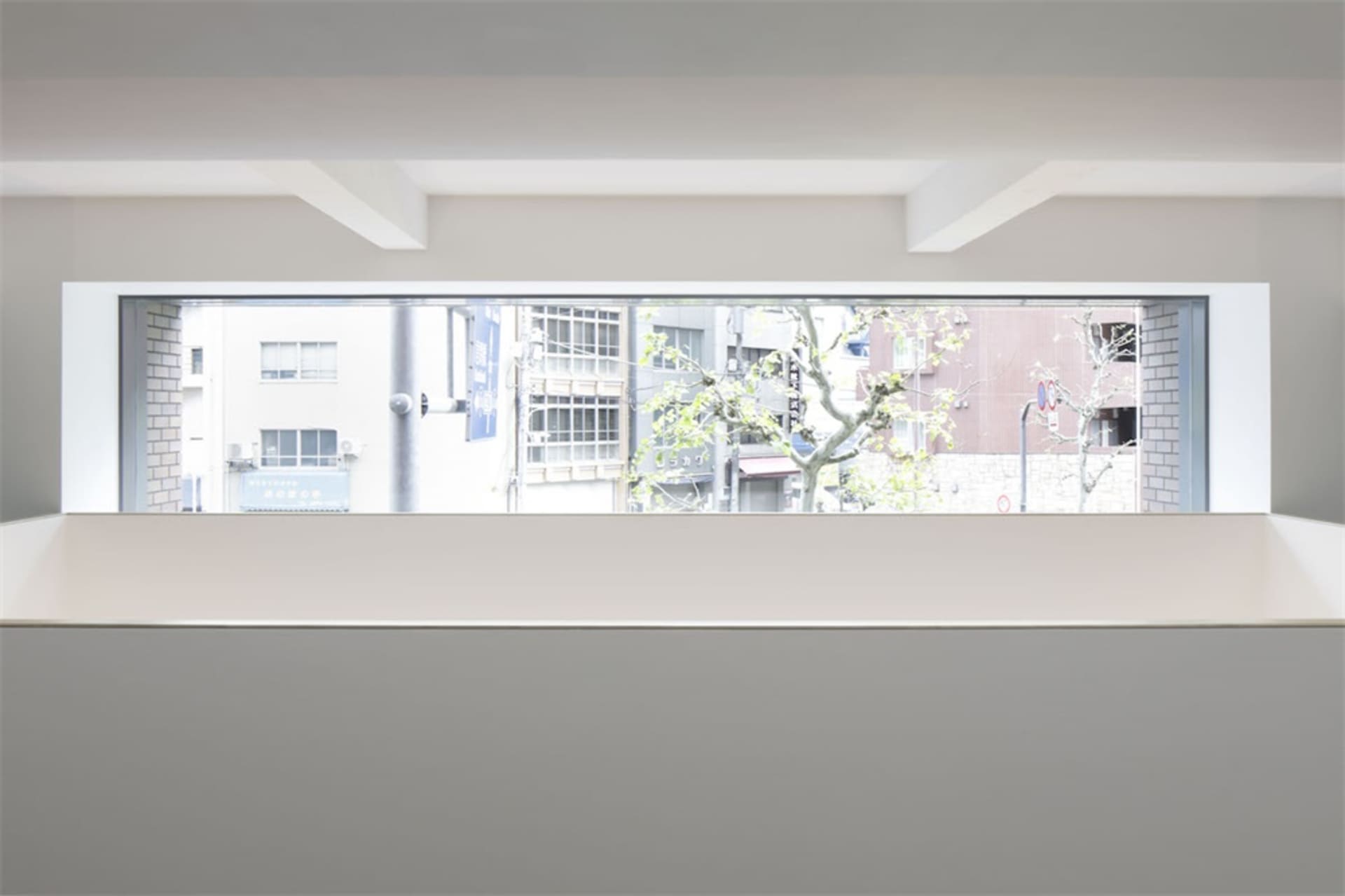 Concrete floor and plaster ceiling with a window view of a cityscape.