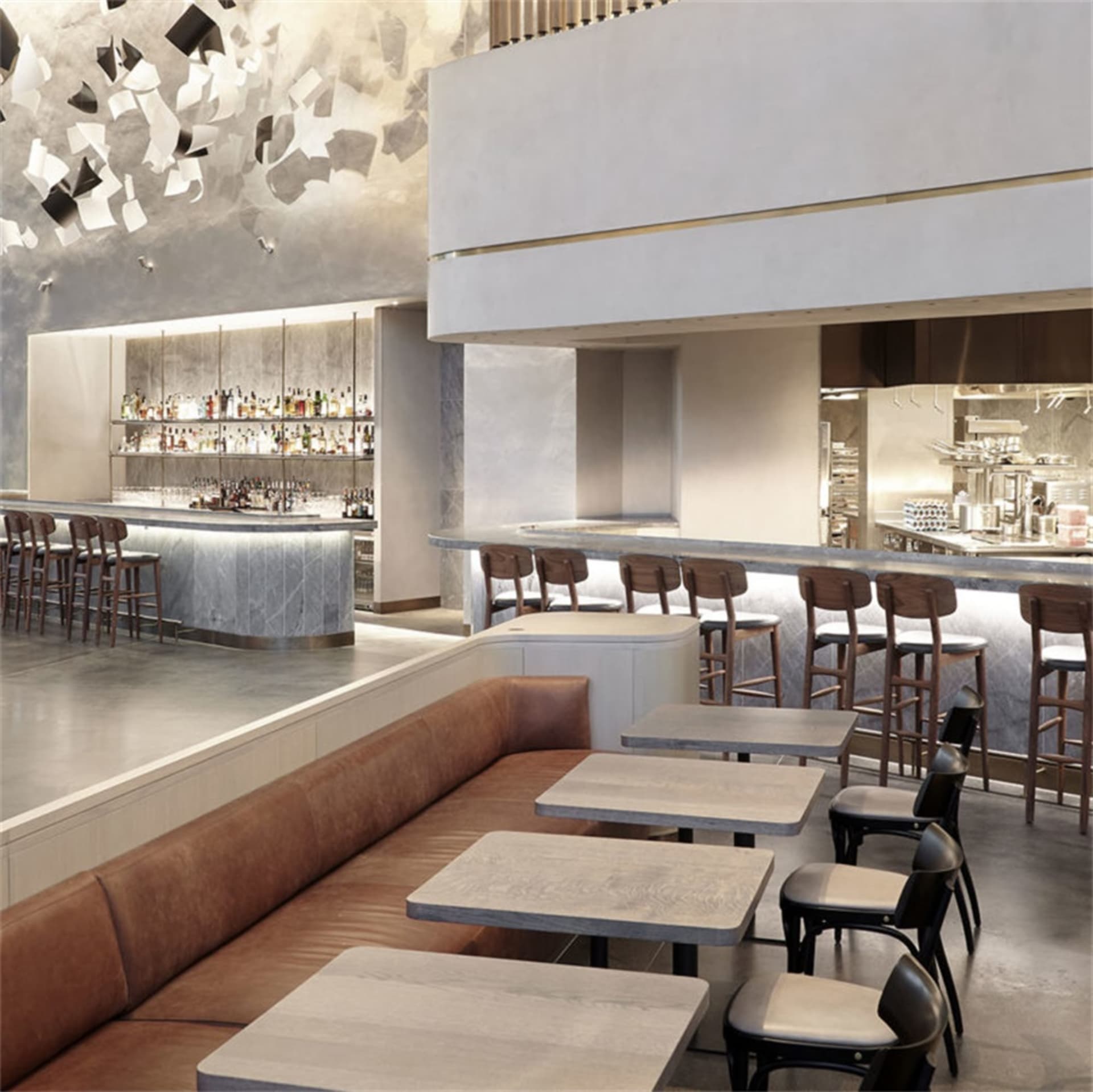 A modern restaurant bar with concrete, marble, wooden, and leather elements.