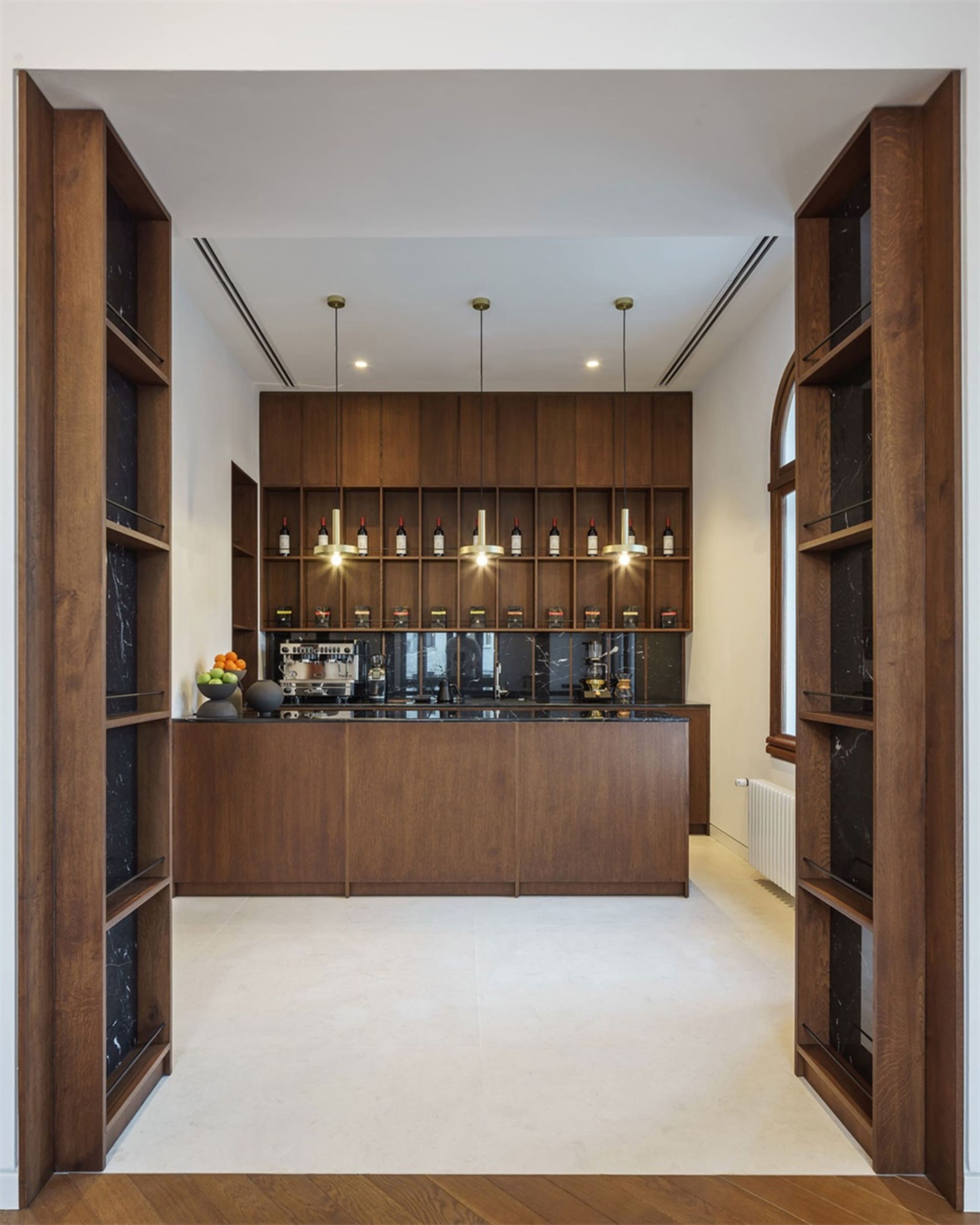 Modern kitchen with wooden cabinets and marble countertops.