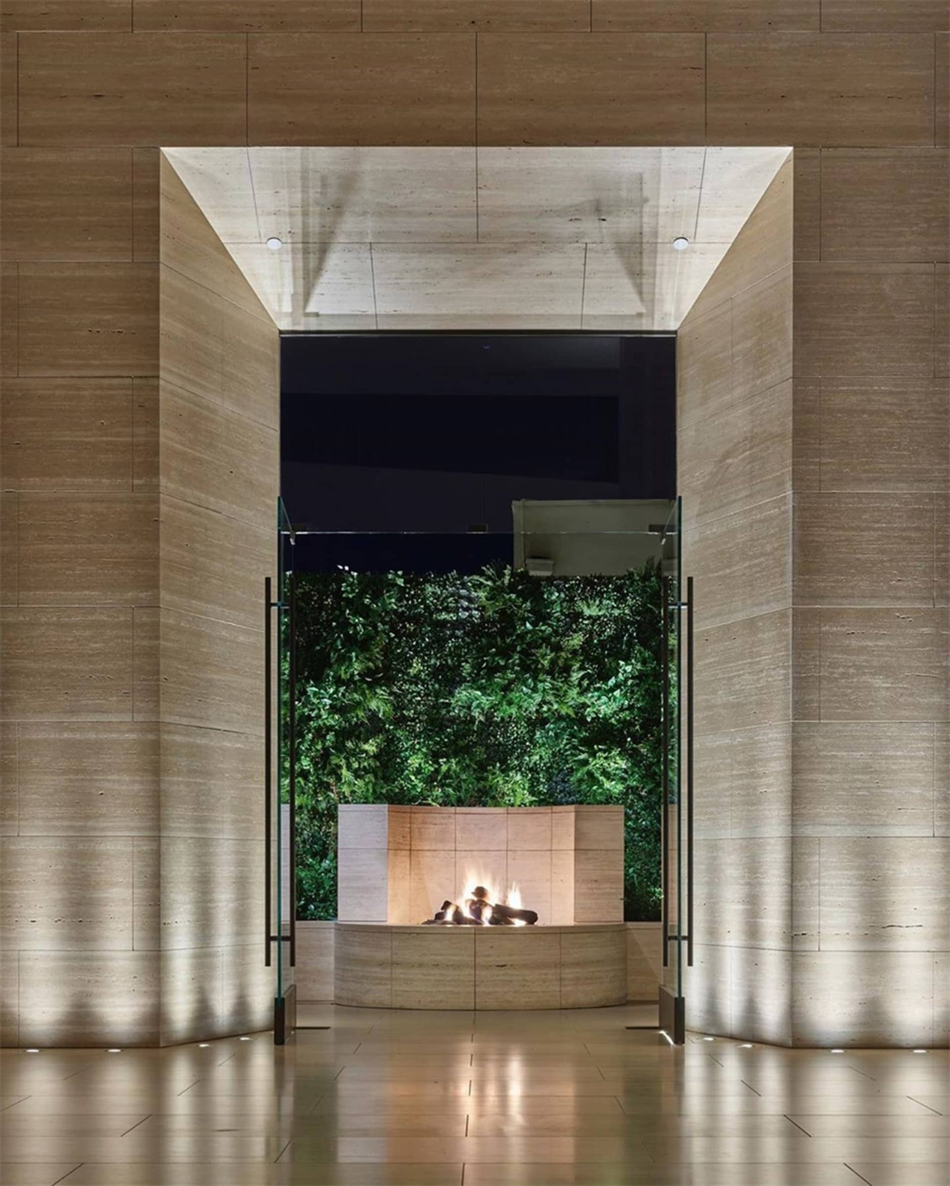 A minimalist lobby features sandstone walls and LED lights.