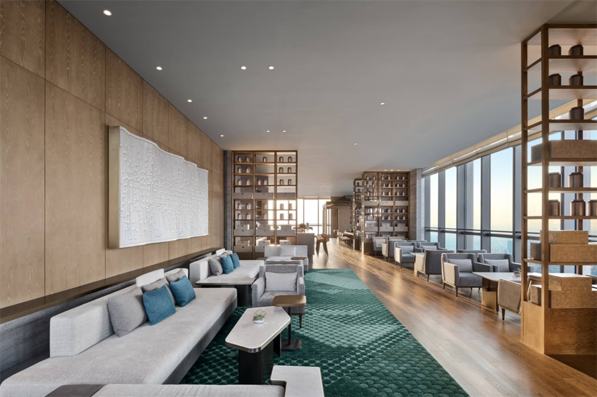 Modern hotel lounge featuring contemporary furniture with wooden, tiled, and concrete finishes.