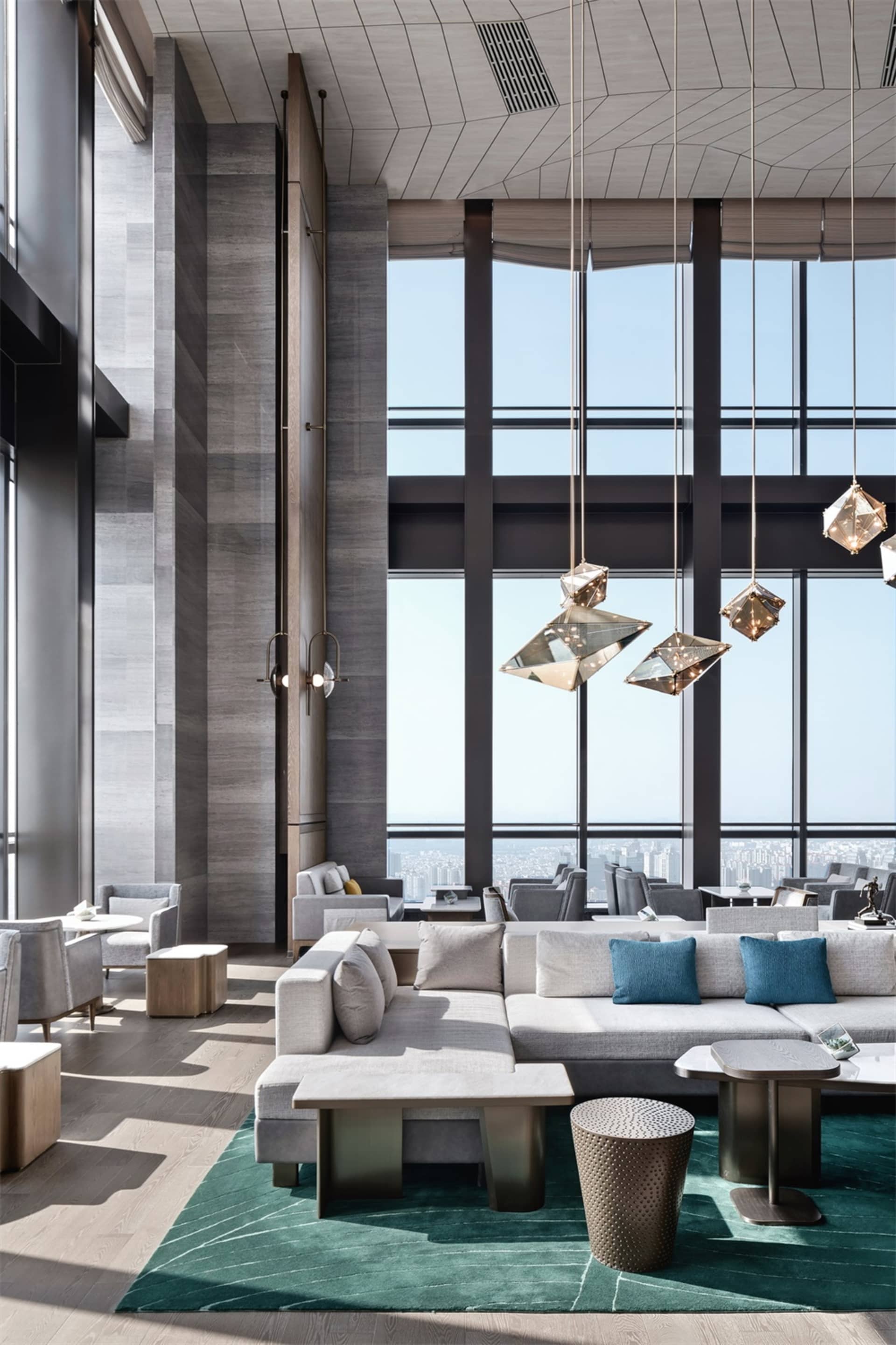 Modern hotel lobby featuring concrete, glass, and metal materials.