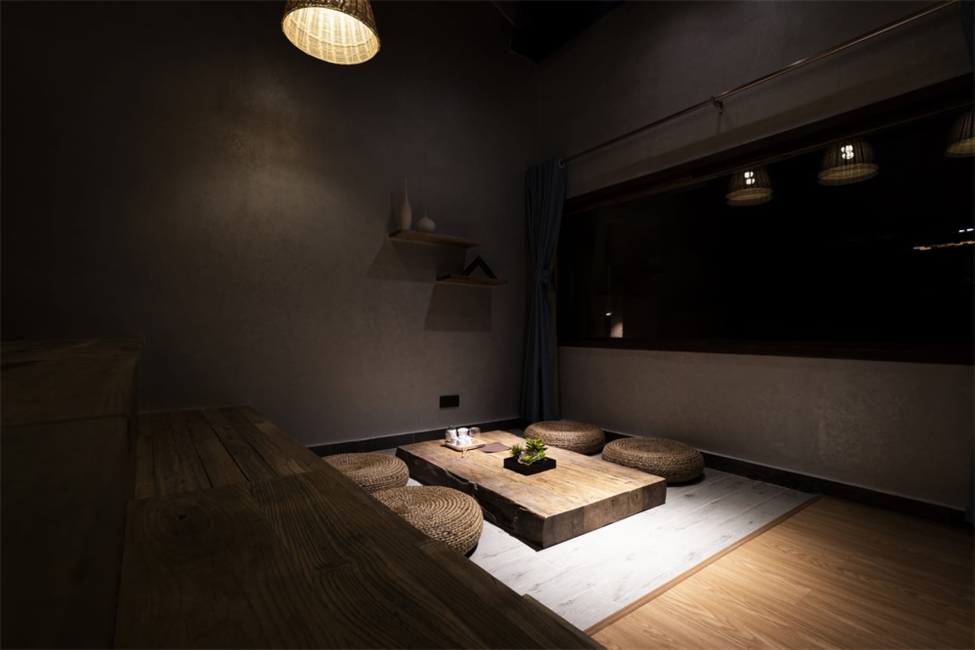 Modern living room with wooden coffee table and woven stools.