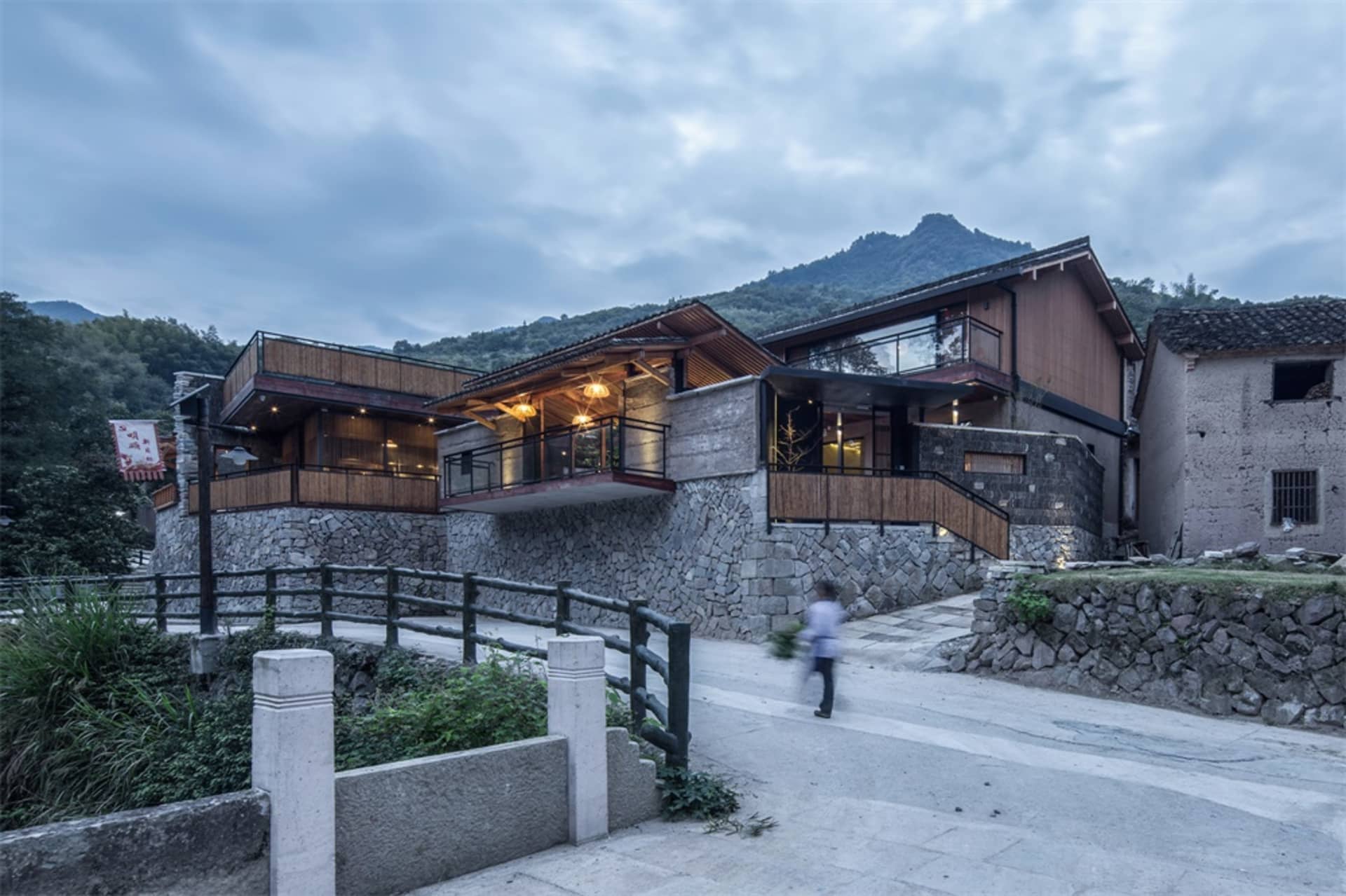 A modern residential house with stone, wood, and glass materials.