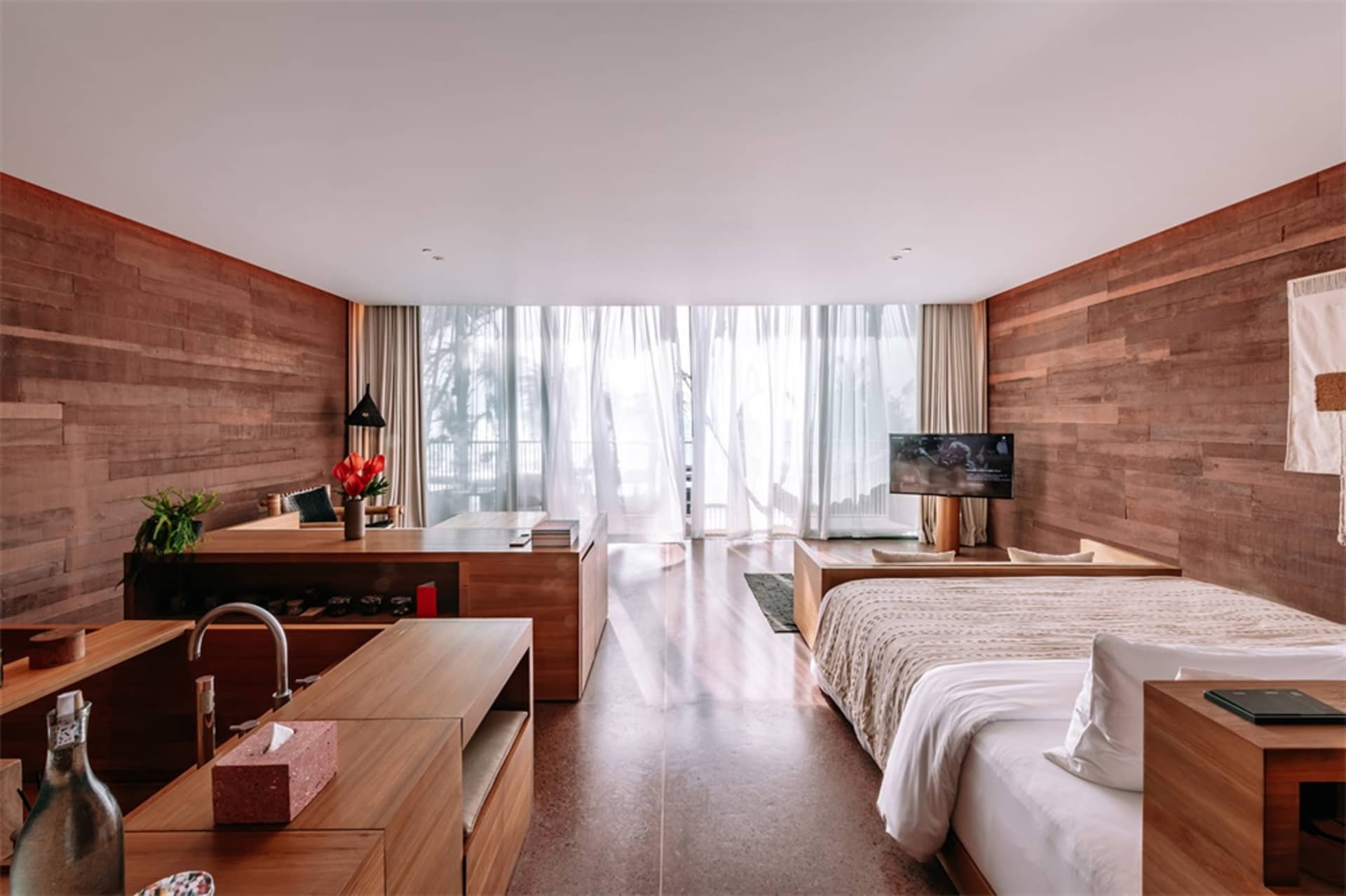 Modern residential interior design featuring a bedroom suite with wooden storage furniture.