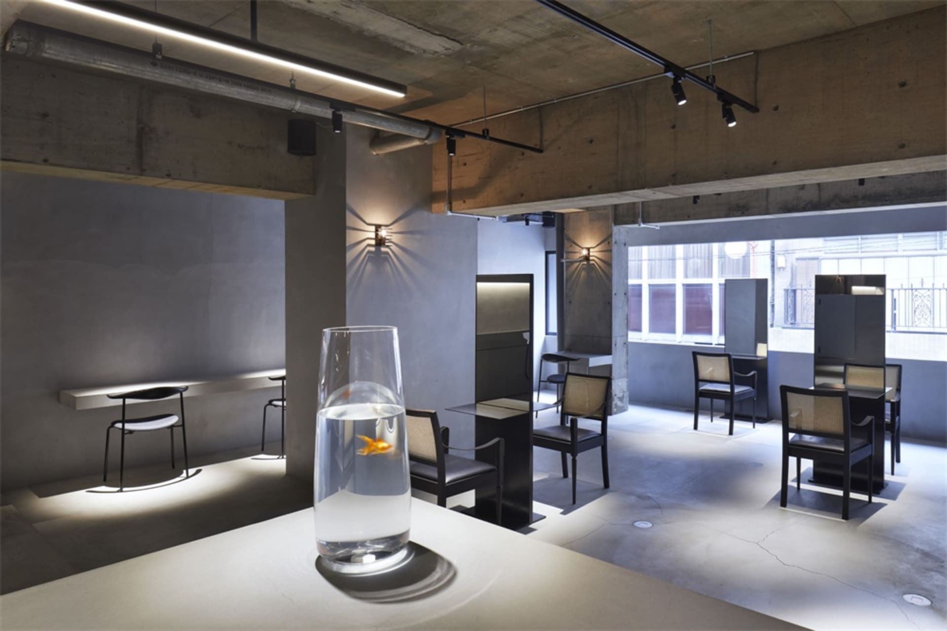 Interior design of a modern restaurant bar with concrete and glass materials.